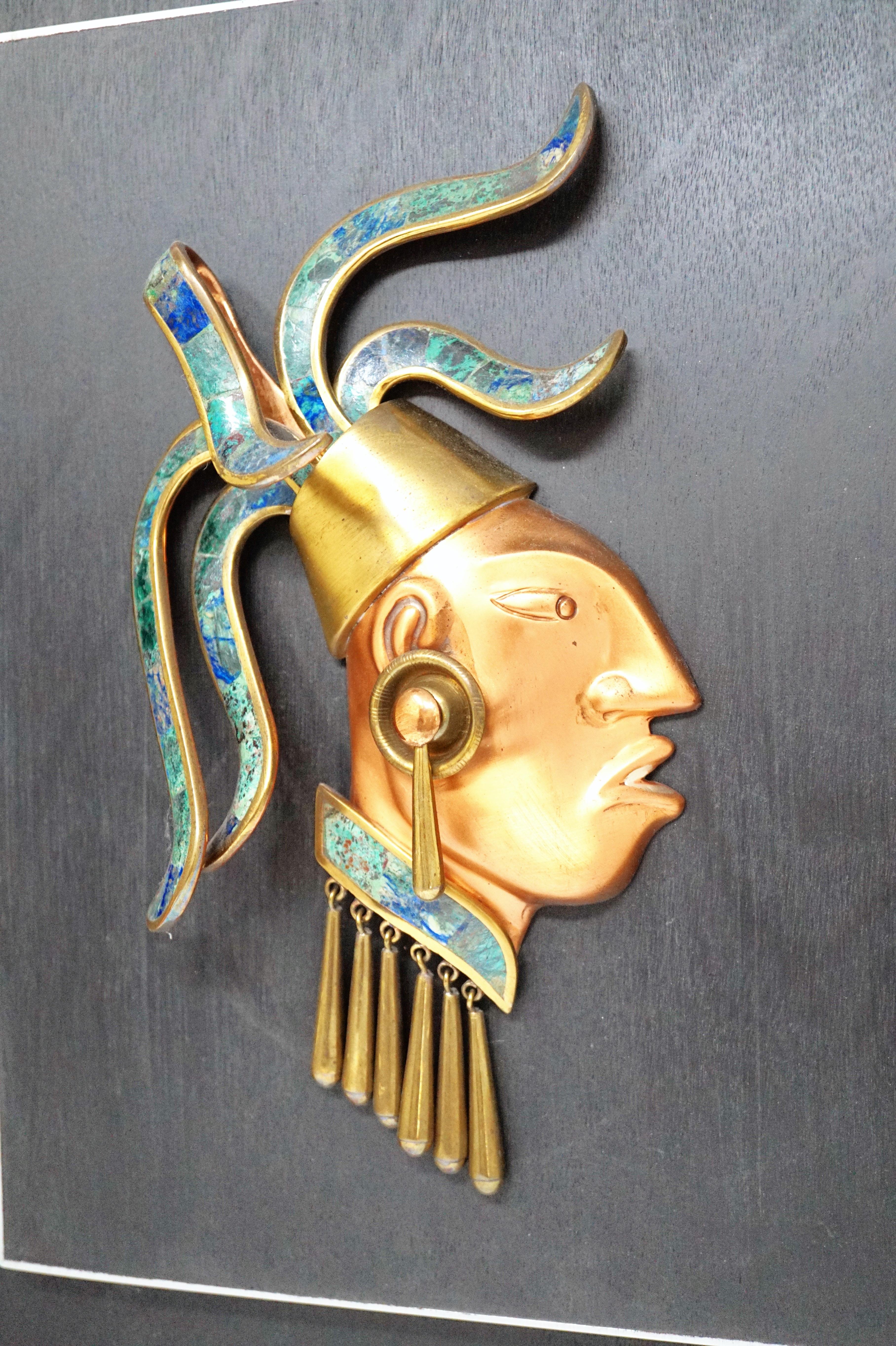 - Depicts a member of Mayan nobility with quetzal feather headdress and three dimensional design elements
- Created using copper, brass, malachite, onyx and turquoise gemstones
- Mounted on wooden board,
- circa mid-20th century
- By Los