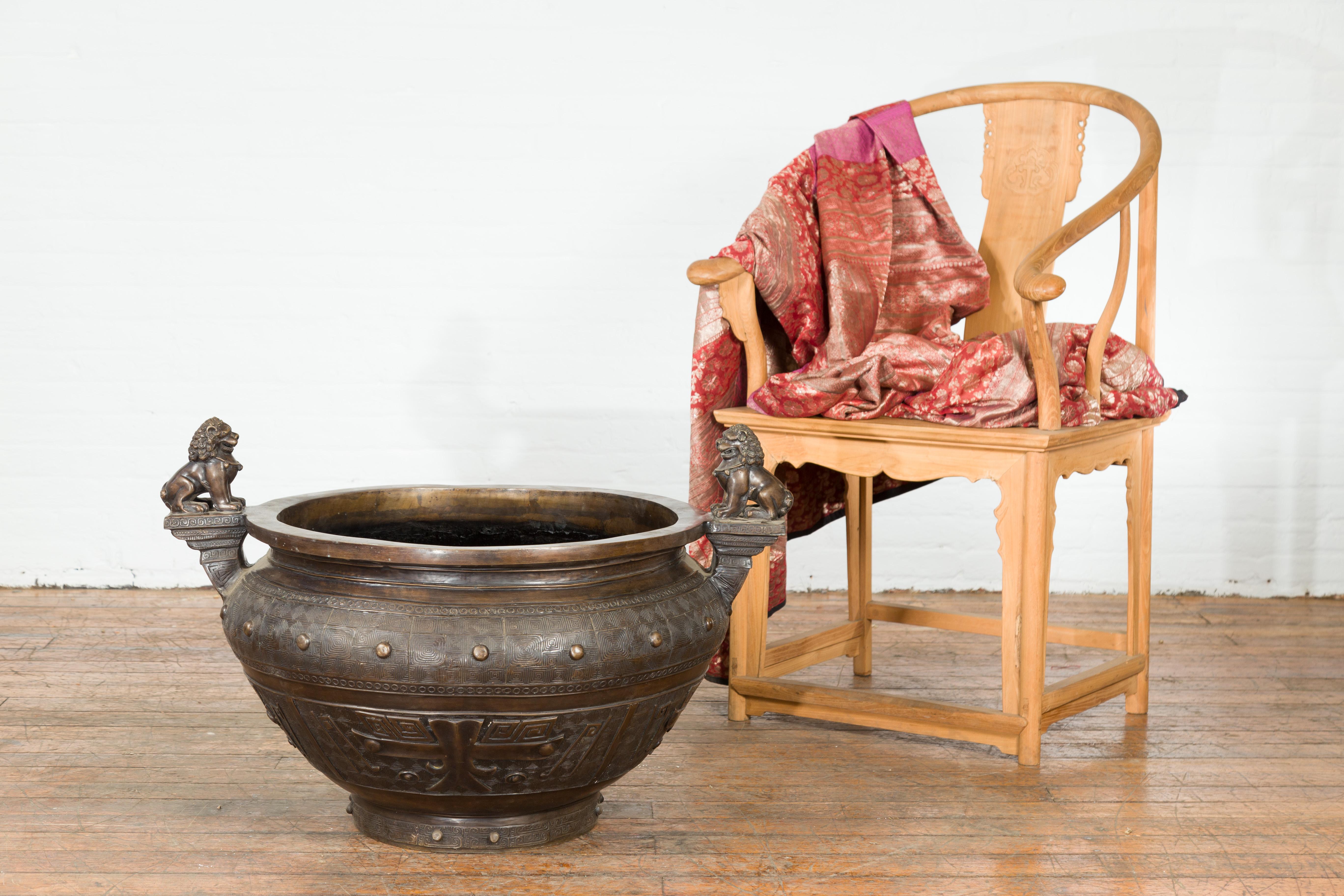 Une lourde jardinière vintage moulée à la cire perdue du milieu du 20ème siècle, avec une patine bronze et des motifs de lion gardien de chien Foo. Nous en avons actuellement deux de disponibles (voir dernière image), dont le prix a été vendu 6 500
