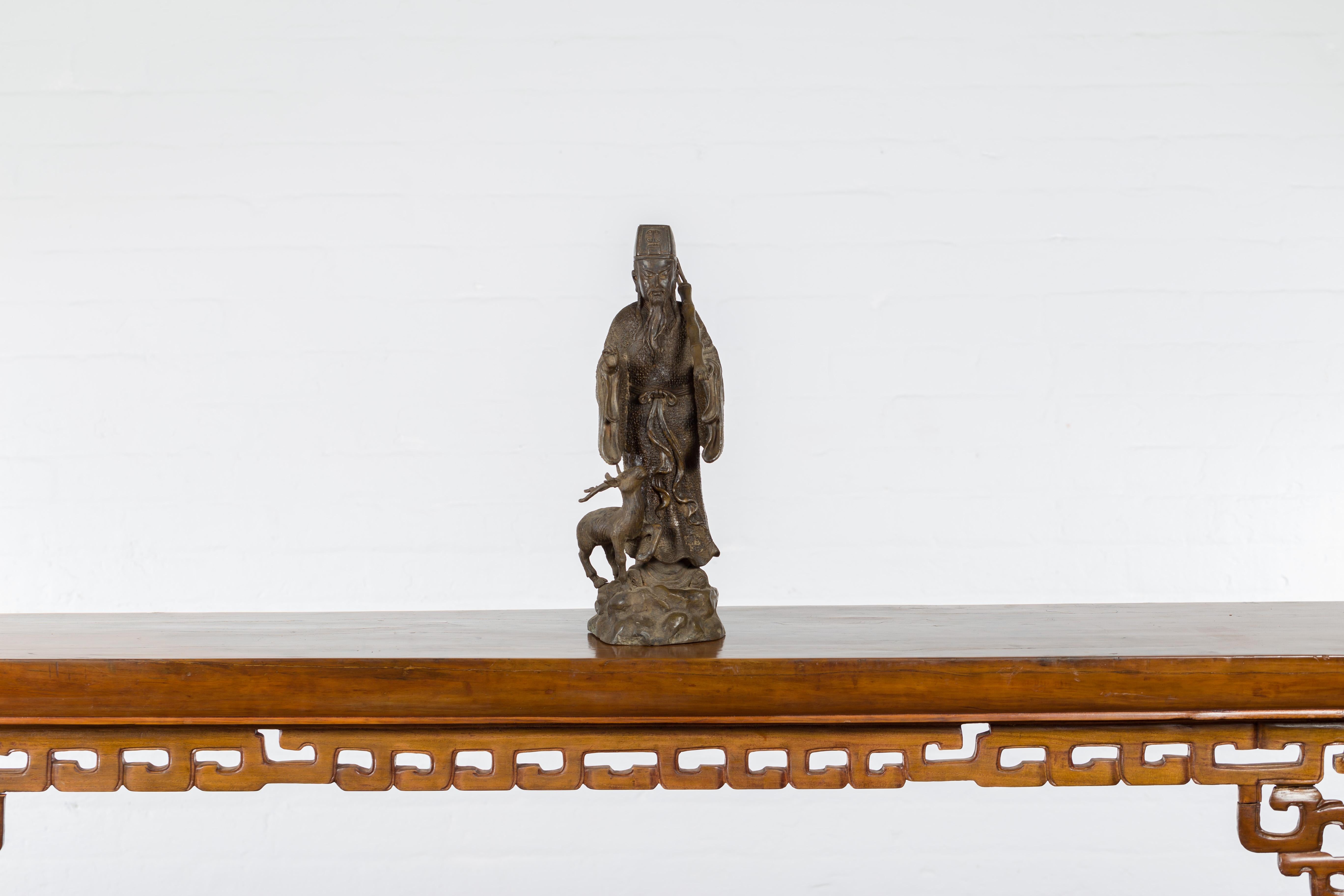 Statuette vintage en bronze coulé à la cire perdue d'une figure ancestrale chinoise à la patine texturée. Créée selon la technique traditionnelle de la cire perdue (à la cire Perdue) qui permet une grande précision dans les détails, cette statuette