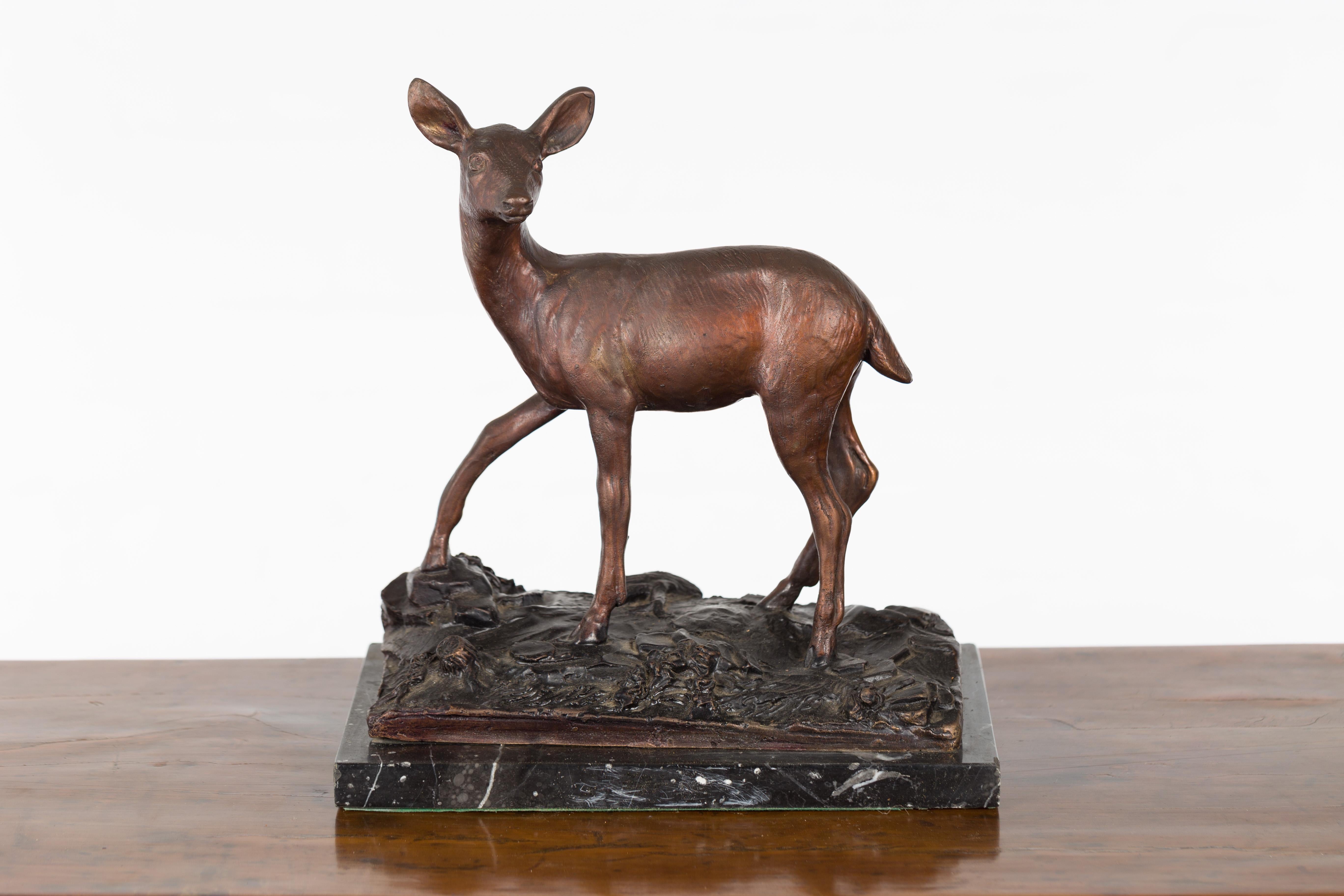 A vintage lost wax cast bronze statuette of a deer on marble base. Created with the traditional technique of the lost-wax (à la cire perdue) which allows for great precision and finesse in the details, this bronze statuette depicts a doe walking on