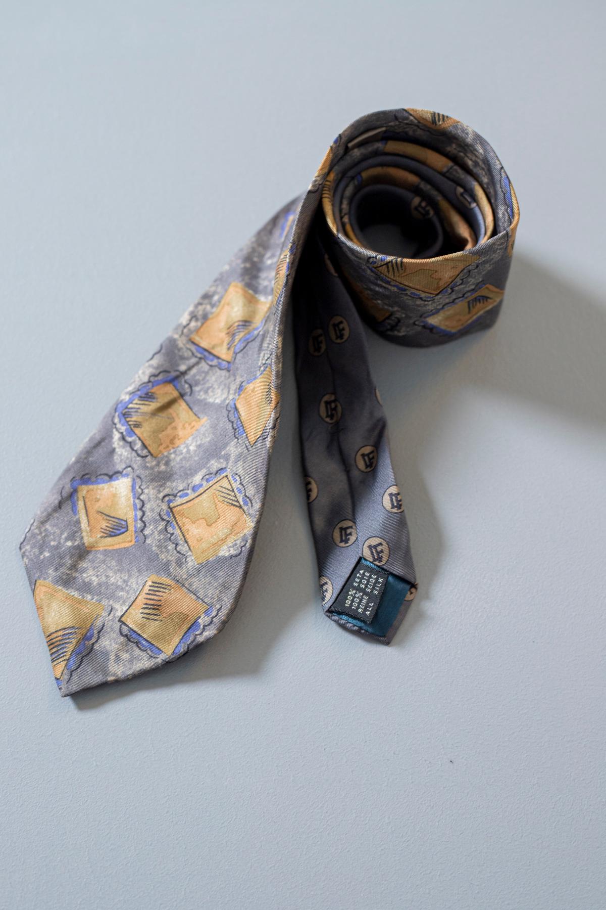 Particular, bizarre and never banal, this tie was designed by the French designer Louis Feraud, it is made of 100% silk. Decorated with small frames on a light blue background, ideal for an evening with friends or a cocktail party, thanks to this