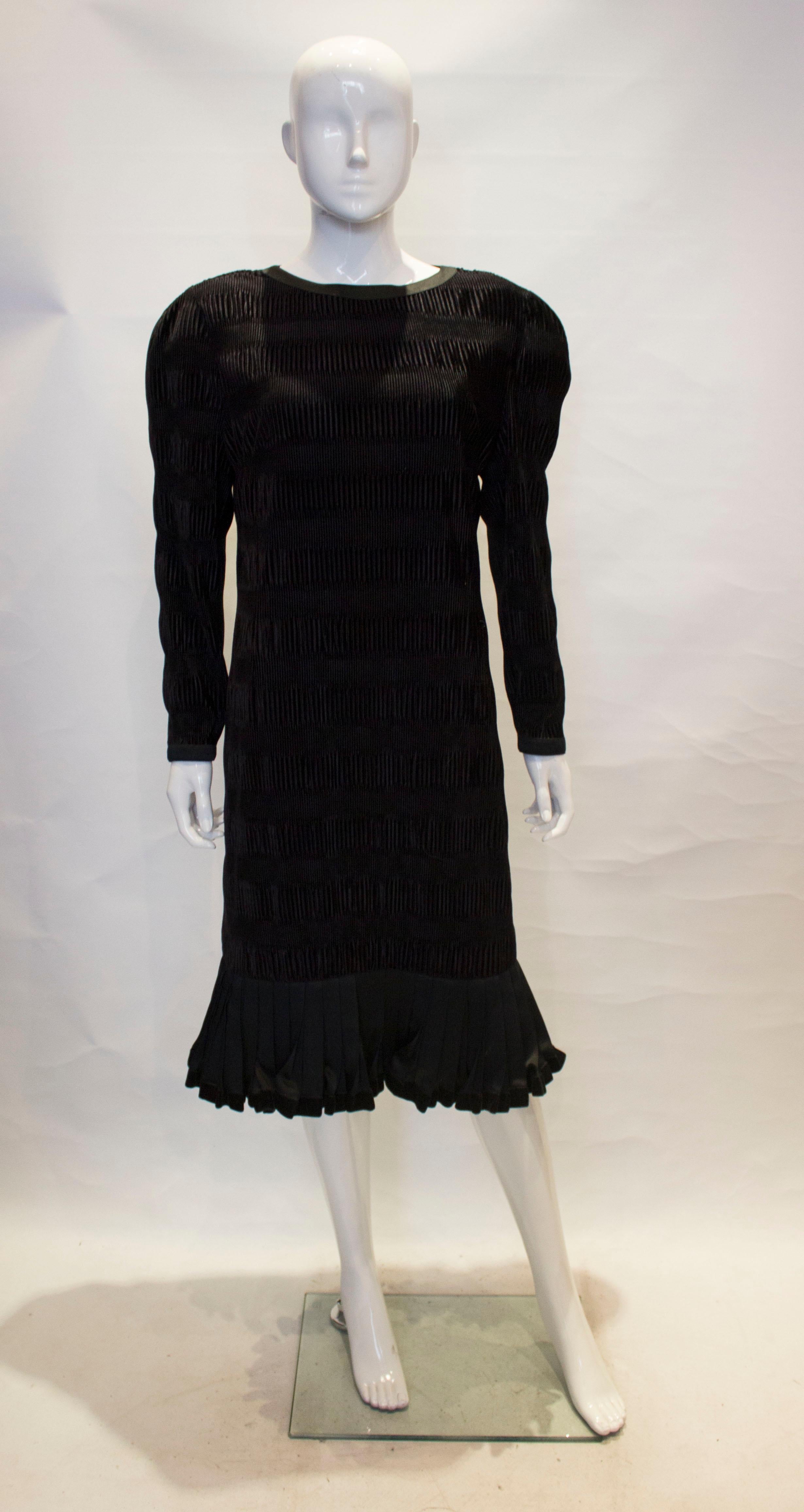 A chic vintage velvet cocktail dress by Louis Feraud . The dress is an unusual ribbed velvet, and has a drop waist, round neck and frill at the hem. It is fully lined with a central back zip.

