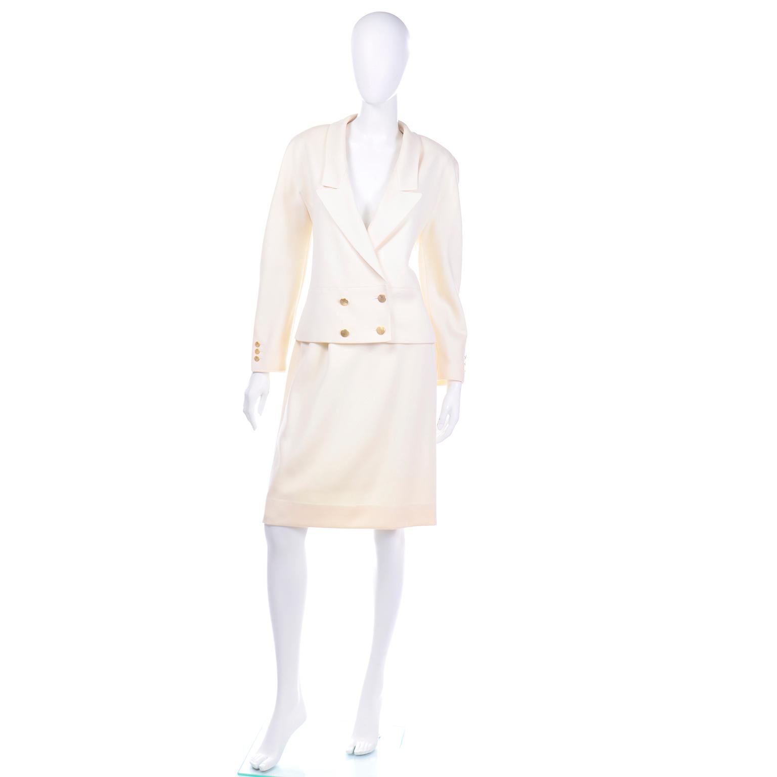 This elegant Louis Féraud cream wool skirt suit is so beautifully made and it comes with a pencil skirt and a double breasted blazer. The jacket has gold tone textured buttons on the cuffs of the sleeves, the double breasted closure and the back of