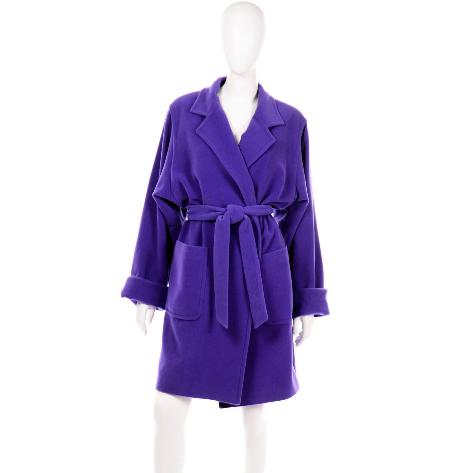 This gorgeous angora wool blend coat is in a beautiful rich jewel tone shade of purple. This trench style coat has a matching fabric belt and deep front pockets. The sleeves are long and wide with big folded cuffs and the coat is fully lined. There