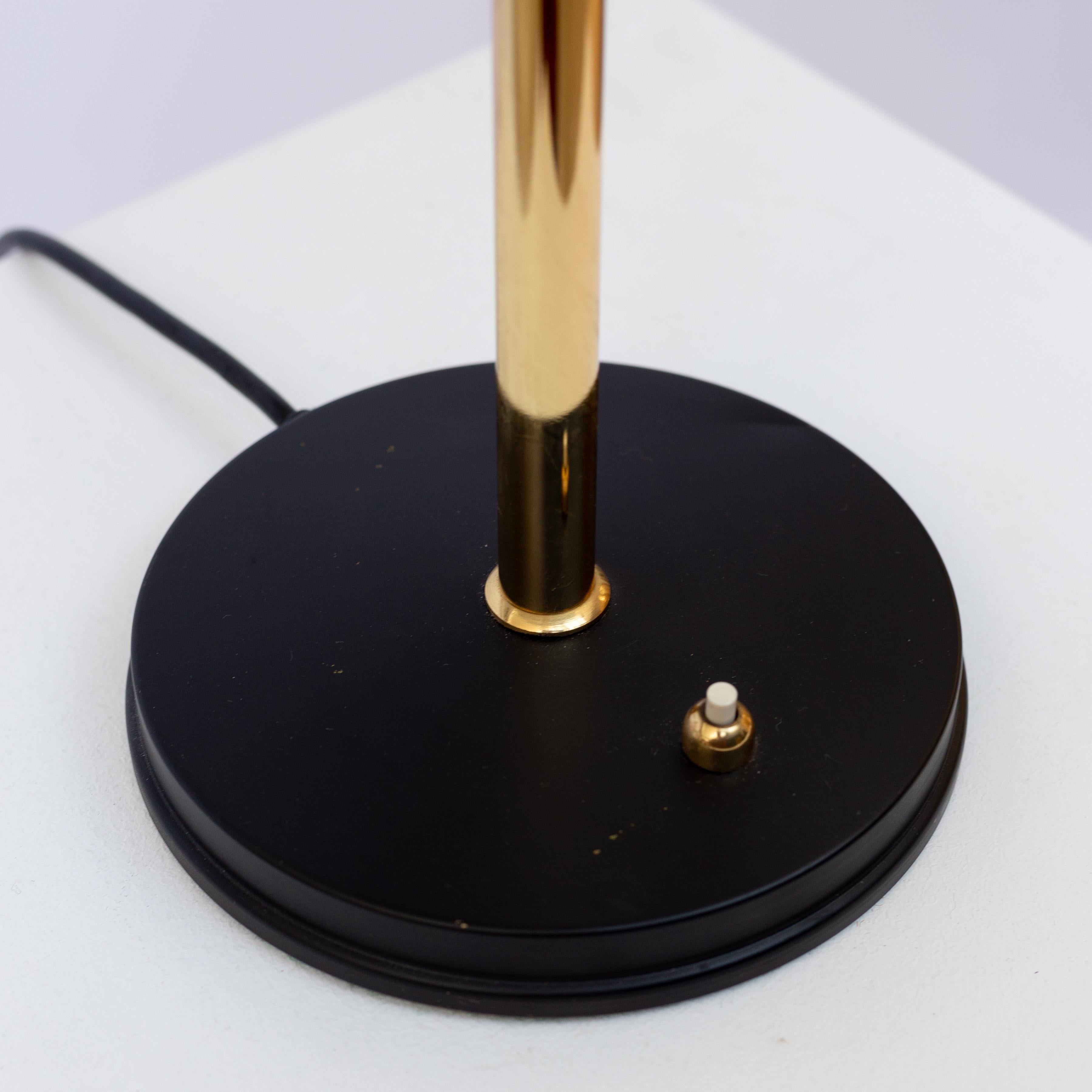 Louis Kalff table lamp made by Philips in the Netherlands in the 1960s. Black lacquered metal and polished brass. Light switch on the base in working order. Good condition with few signs of wear and patina. The model 'Timor' desk lamp is one of his