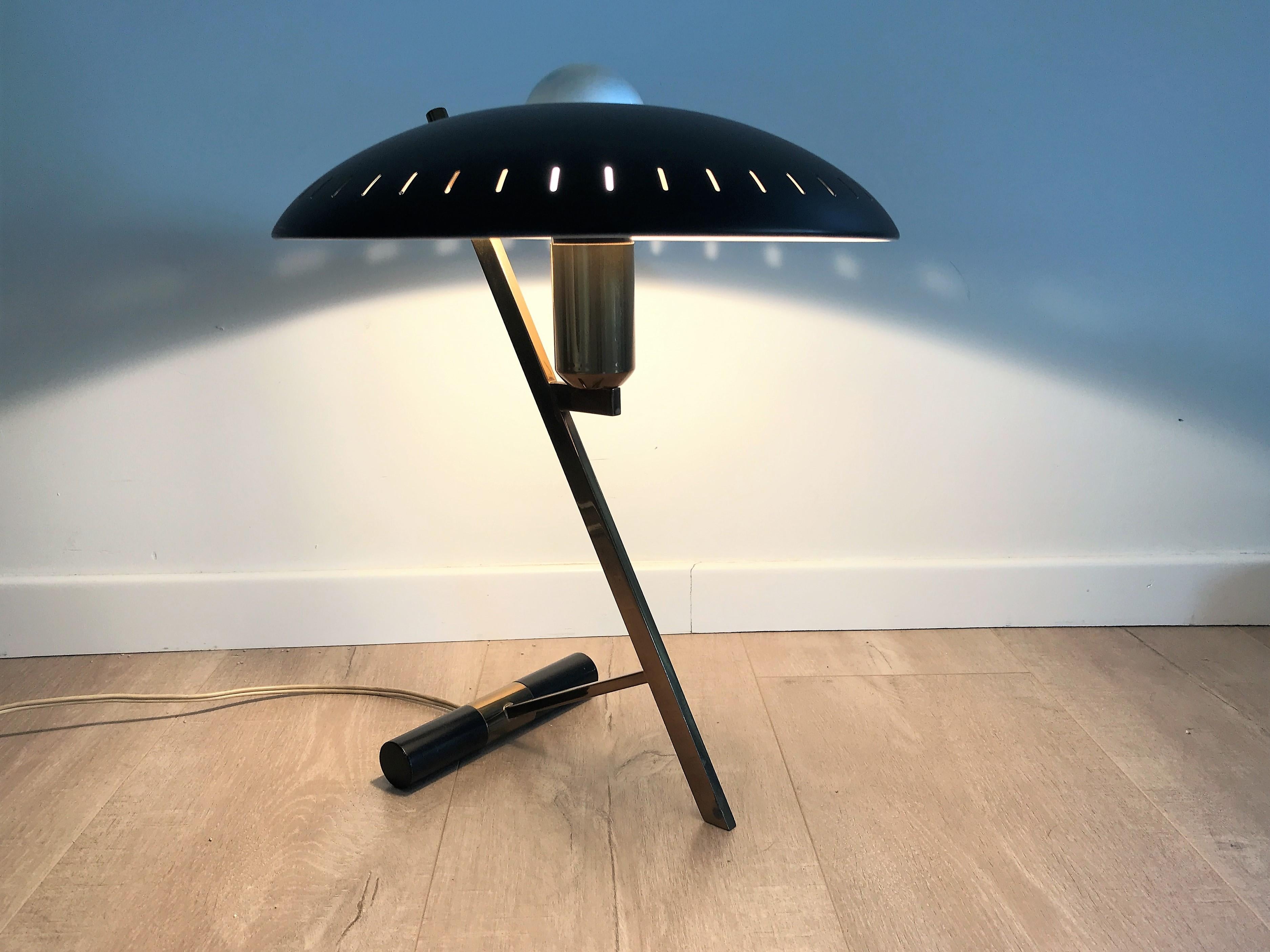 Black Z model table lamp design by Louis Kalff for Philips.

This model is one of Louis Kalff's best designs.

It features a brass Z-shaped base with a single light point.

The shade is made of perforated aluminum with an enamel finish to emit