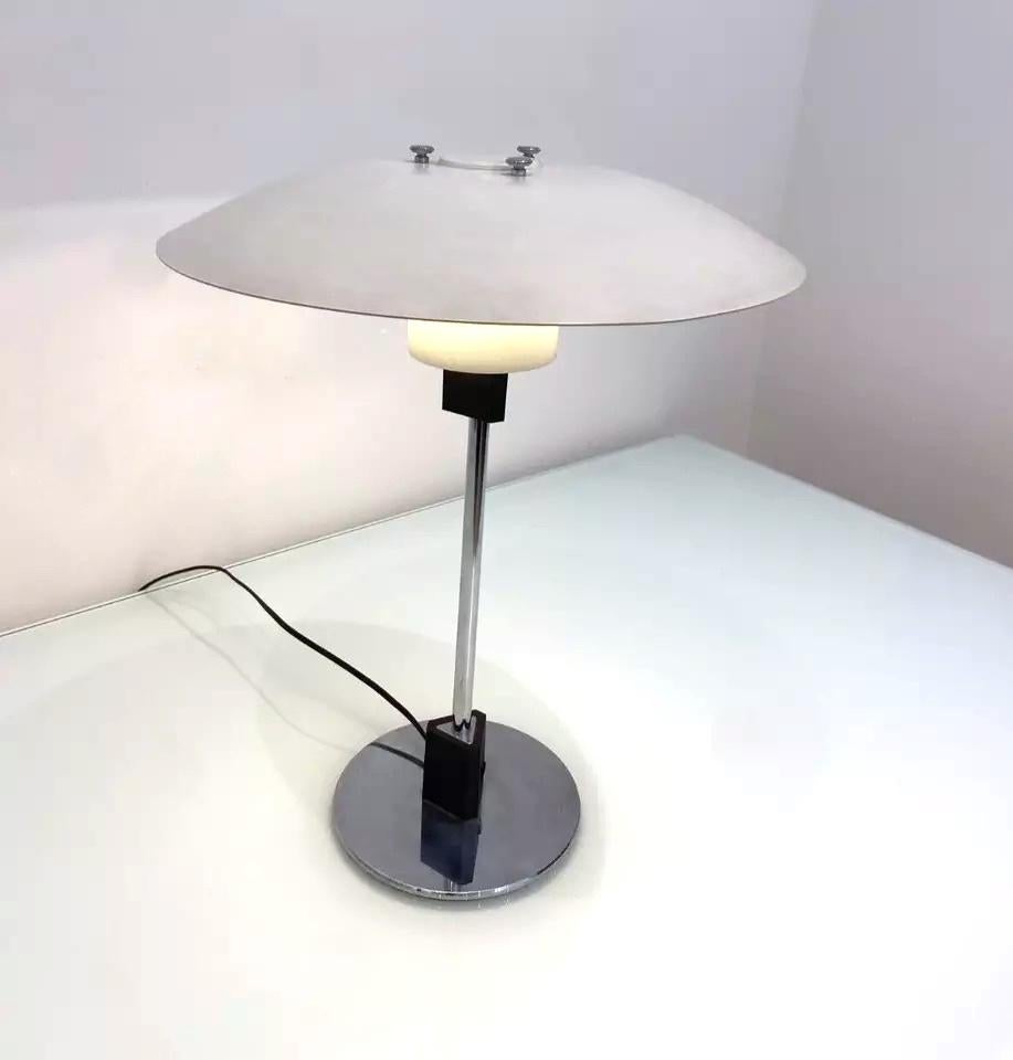 Cette lampe de table modèle 4/3 du milieu du siècle dernier, conçue par l'architecte et designer d'éclairage Poul Henningsen, présente le design classique de l'abat-jour en gradins de Louis Poulsen. Finition en acier blanc et base