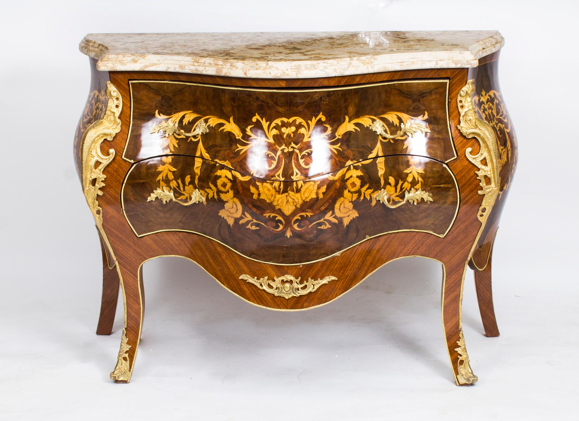 This is a stunning Louis revival marble topped 'bombe' marquetry commode, dating from the last quarter of the 20th century.

This beautiful commode is made from walnut and features exquisite floral marquetry decoration and ormolu mounts. It has two
