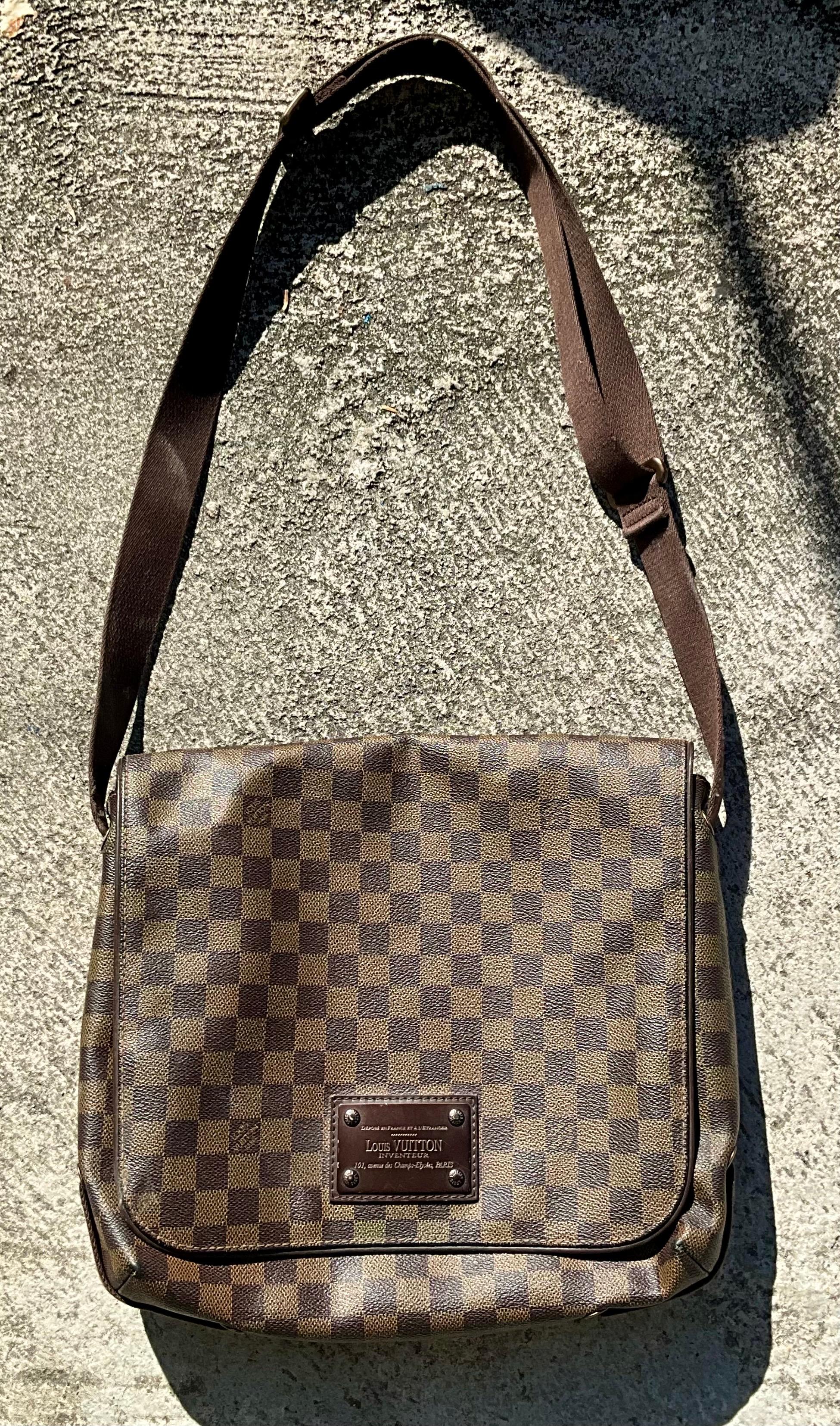 The Louis Vuitton Damier Ebene Messenger Bag is a stylish and functional piece that embodies the brand's signature craftsmanship, blending practicality with luxury. 

The bag is crafted from Louis Vuitton's signature Damier Ebene canvas, which