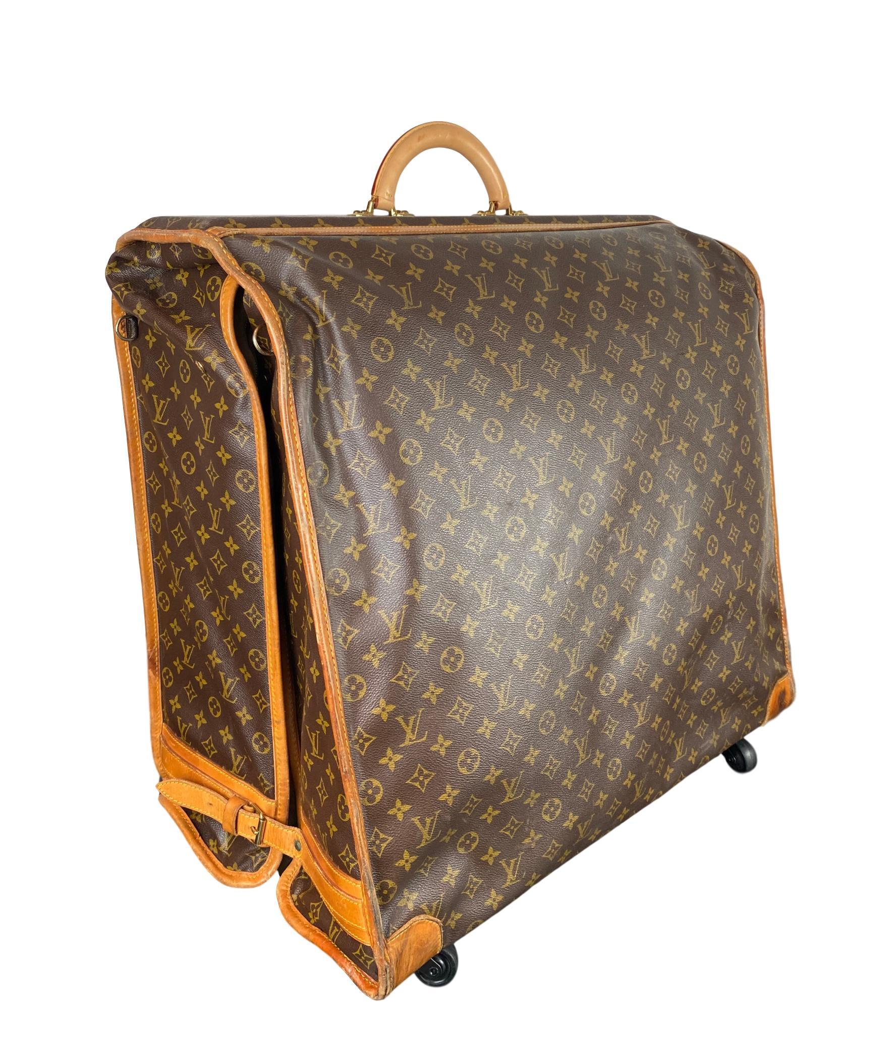 Vintage Louis Vuitton Large Folding Garment Monogram Luggage, circa 1970. This rare vintage garment bag comes in the classic Louis Vuitton Monogram canvas with a brand new rolled top vachetta handle, original vachetta pipping, buckle lock closures