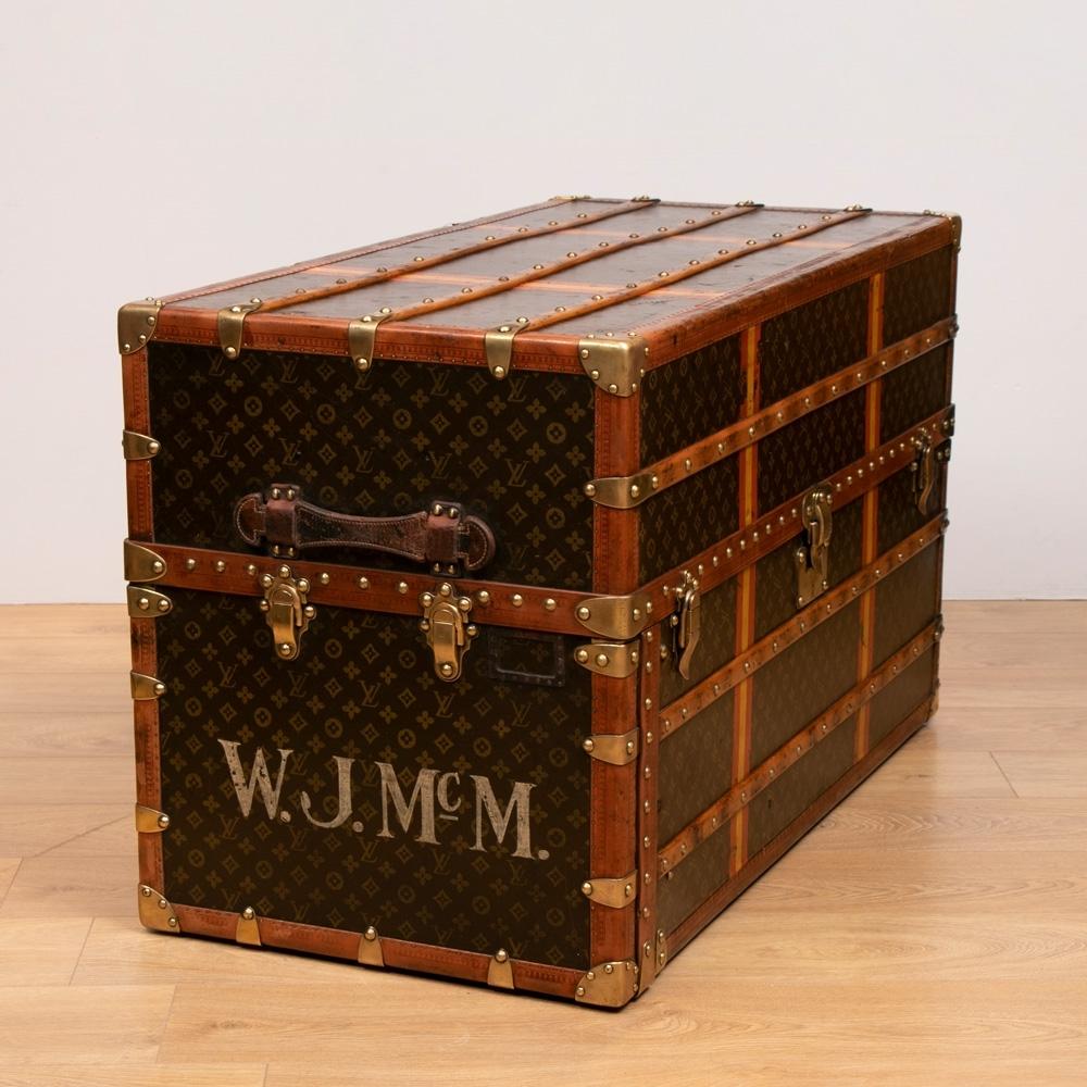 A vintage Louis Vuitton Malle Armoire wardrobe and chest of drawers, trunk, c.1900-1910. The trunk magically contains wardrobe space and 6 drawers with original stencilled fabric to the exterior and brass and wood bindings.