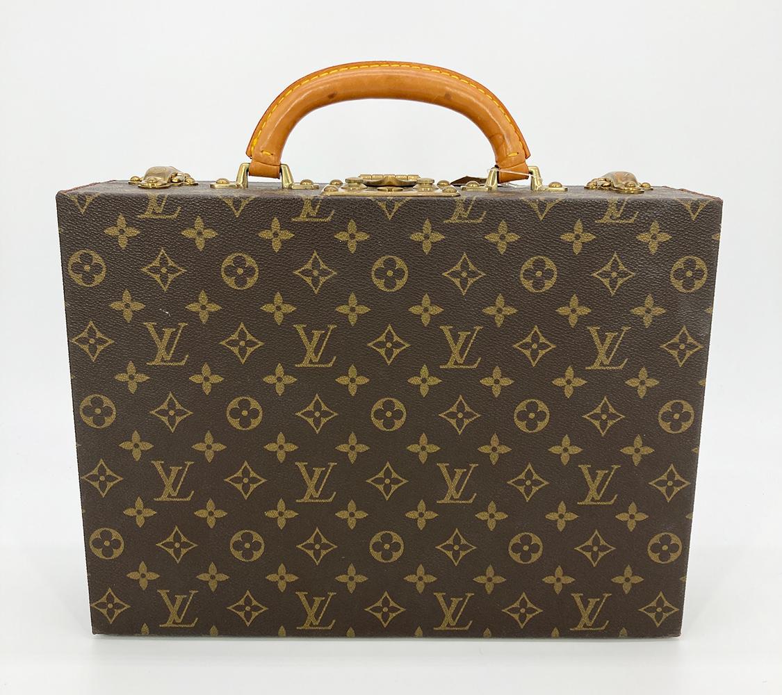 Vintage Louis Vuitton Monogram Jewelry Case c1970s in excellent condition. Signature monogram canvas exterior with brass hardware and leather handle. Triple latch closure opens to a brown vuittonite and velvet interior with one removable storage
