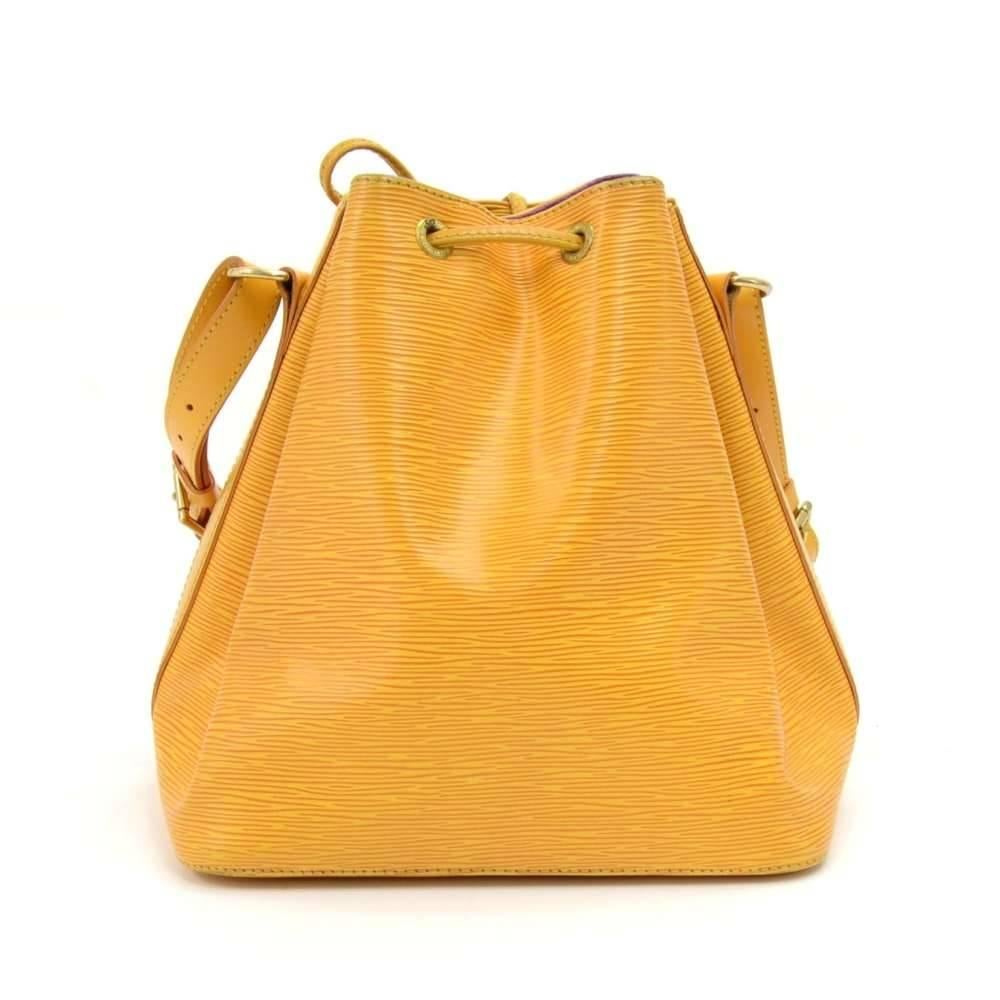 Vintage Louis Vuitton Petit Noe a smaller-scale interpretation of the famous champagne bag created in 1932. This Petit Noé is styled in yellow Epi leather. Leather strap closure, adjustable shoulder strap.  Inside is lined with lovely purple