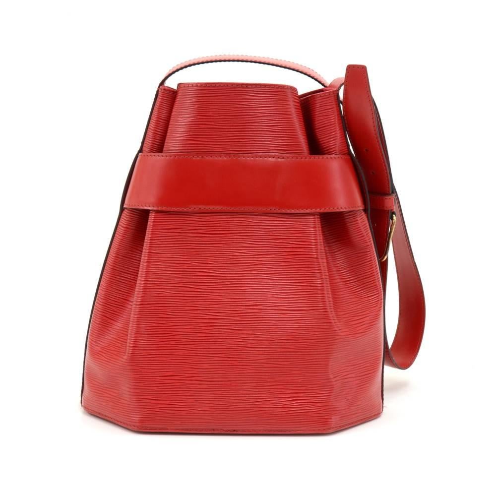 Vintage Louis Vuitton Red Sac D'epaule Epi leather shoulder bag. It has open access with a leather strap around the top of the bag secured with a stud. It is carried on the shoulder with its adjustable shoulder strap. Inside has alkantra lining with