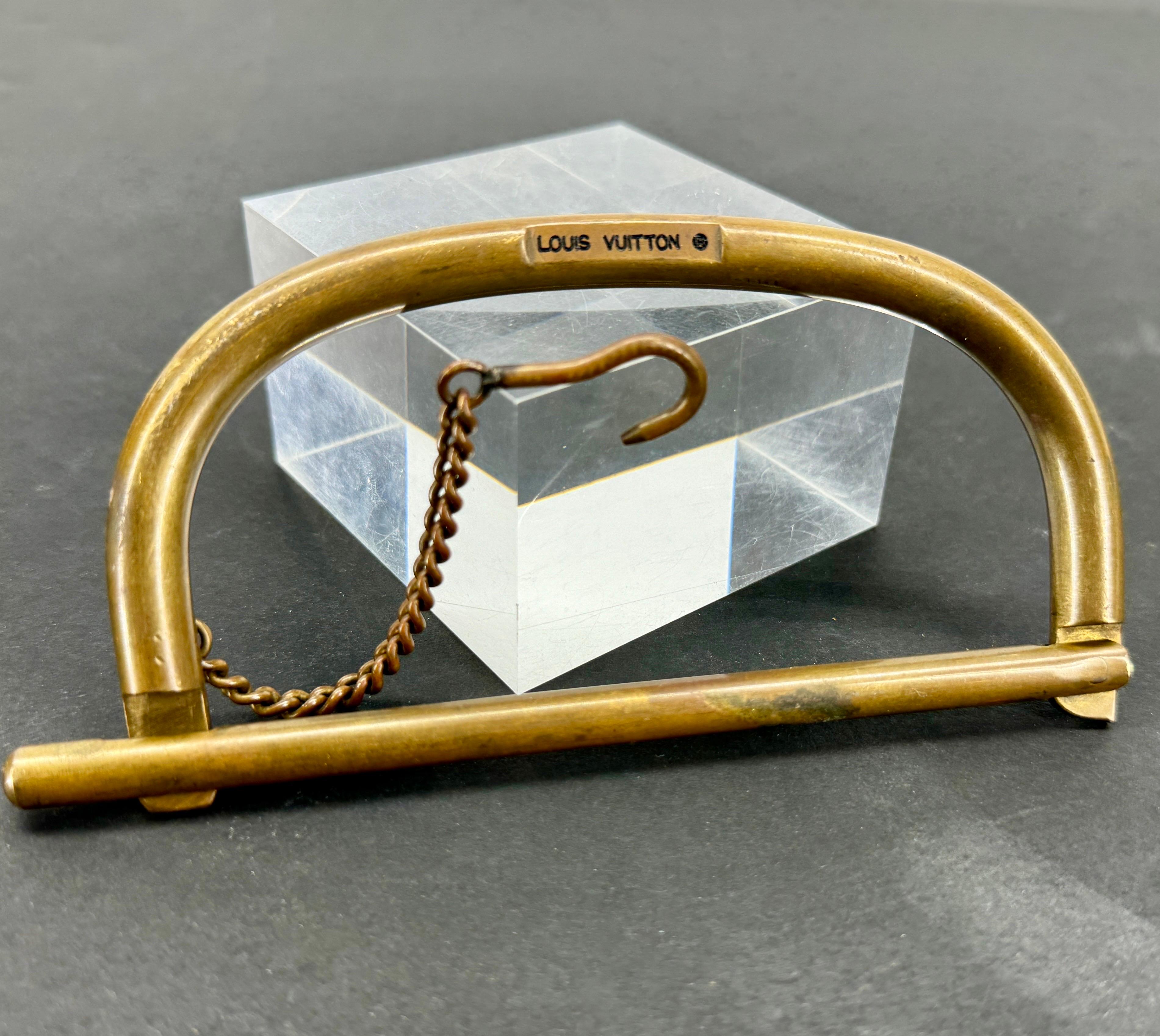 Old Brass Handle and Chain Hardware From an Authenticated Louis Vuitton Luggage Duffle Bag, marked Louis Vuitton.

This rare piece of hardware is almost impossible to come by. The marked piece was essential in keeping the duffle closed. 