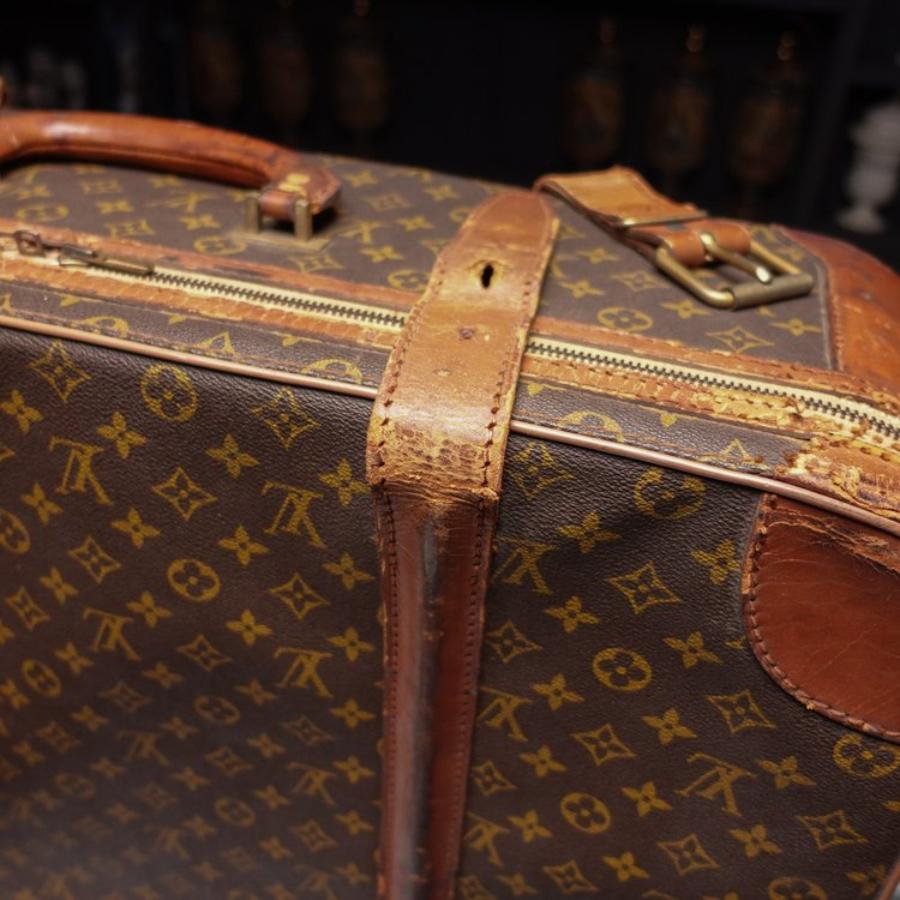 Here is a Vintage Louis Vuitton Soft Top Suitcase. It features gold-tone hardware, natural cowhide leather trim, leather handle, composite canvas and a full double zipper closure. Interior of luggage case is roomy and fully-lined in beige canvas