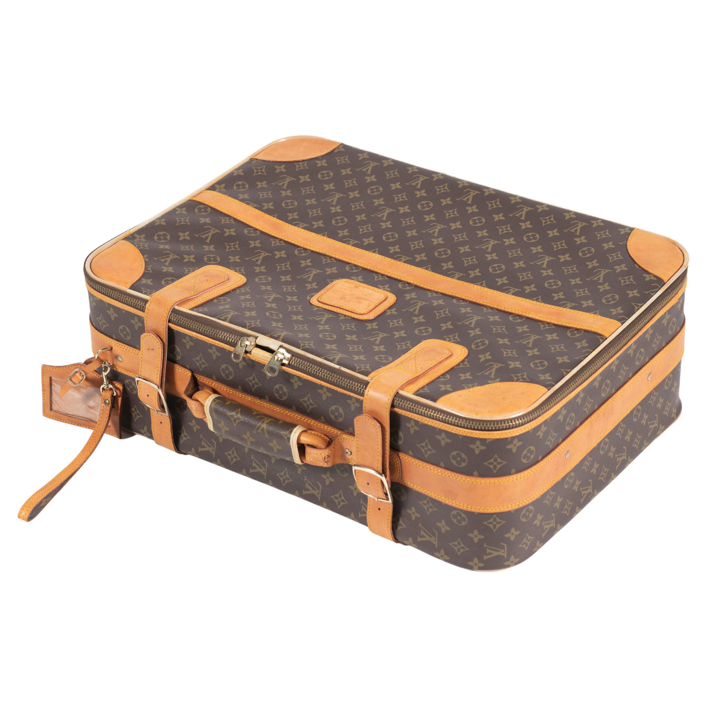 Vintage classic Louis Vuitton soft side suitcase with leather trims, zipper closure and wheels for easy transport. Open interior for you to pack as you like. Small-sized. 
