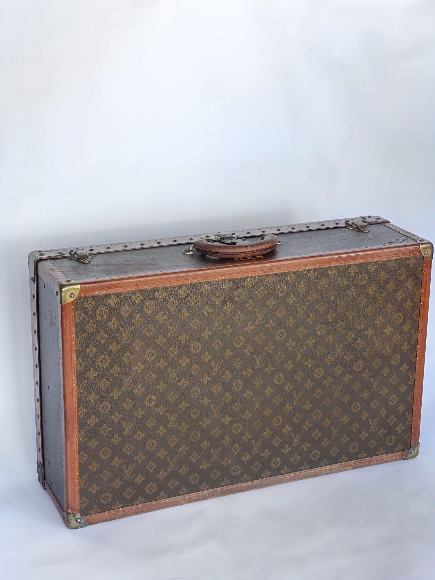 Serial R05966, monogrammed LV canvas having gold toned brass hardware, lock, (2) trunk latches all having LV monogram, Vachetta leather handle and strapping, linen lined interior and removable inner tray, retaining a 'Saks' label inside and outside