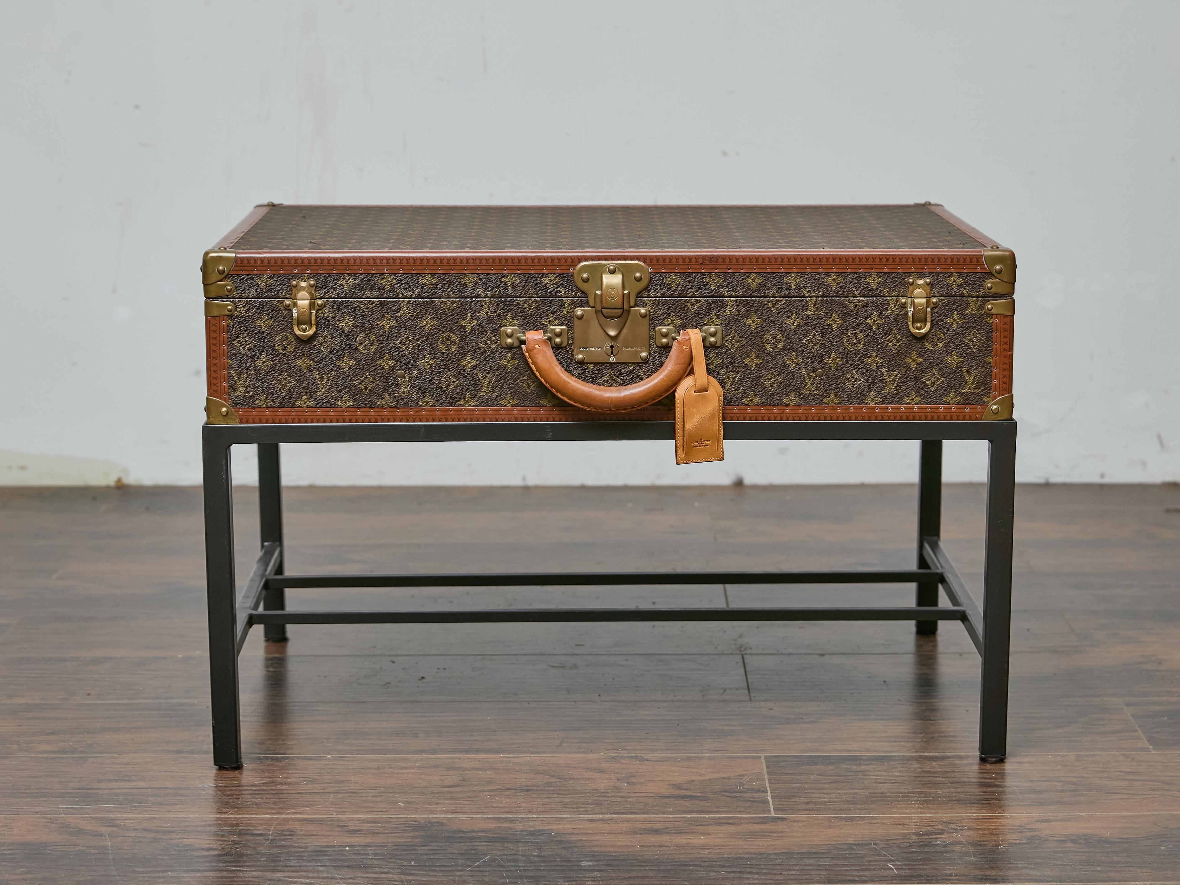 A vintage Louis Vuitton trunk from the late 1970s to early 1980s finds new life as a distinctive coffee table, seamlessly blending luxury with functionality. The monogrammed canvas, framed by signature lozine trim and reinforced brass hardware,