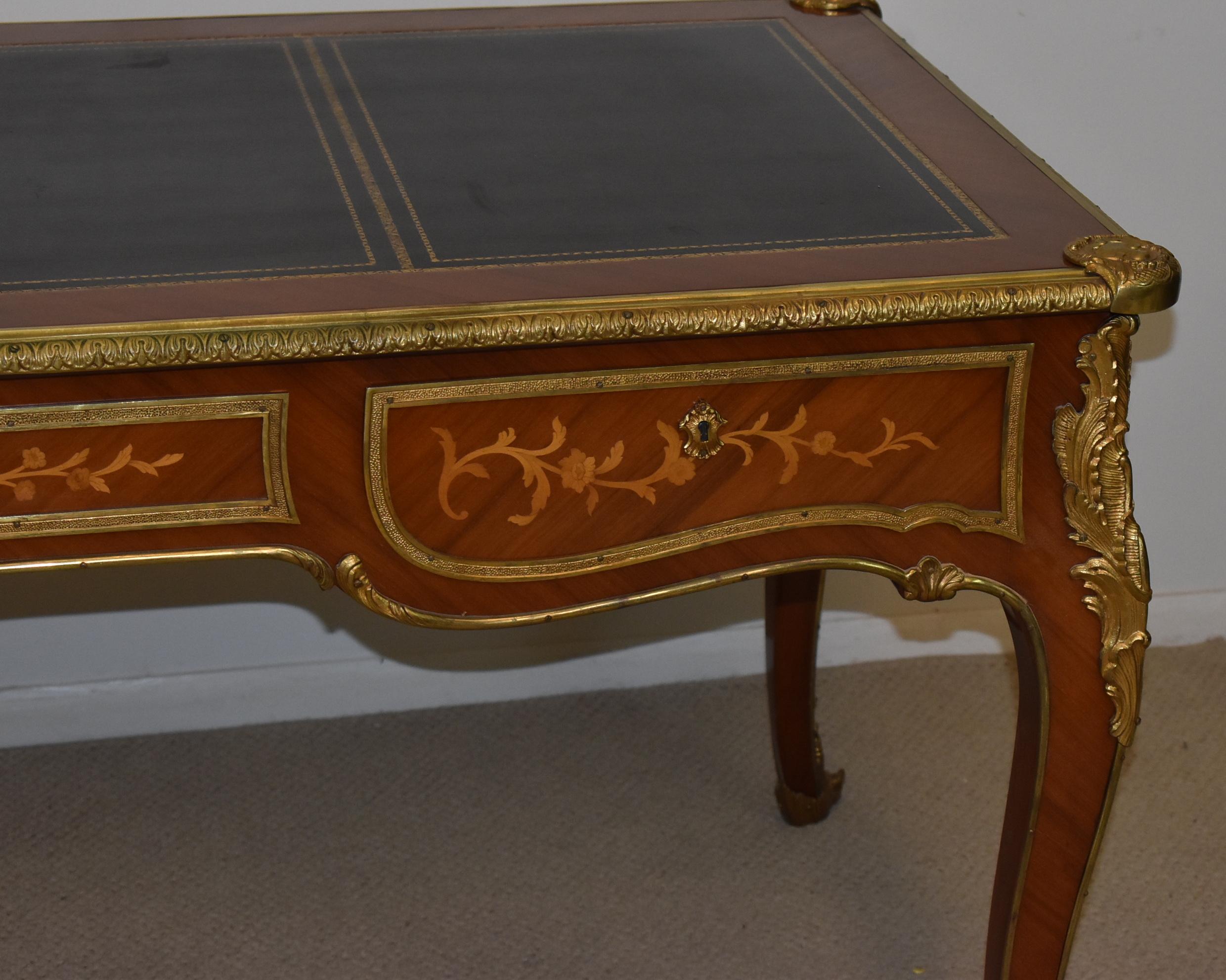 Vintage Louis XV executive writing desk. Leather top and applied brass mounts. Satinwood inlay vine and flower designs. Three locking drawers. Finished on all four sides. 70