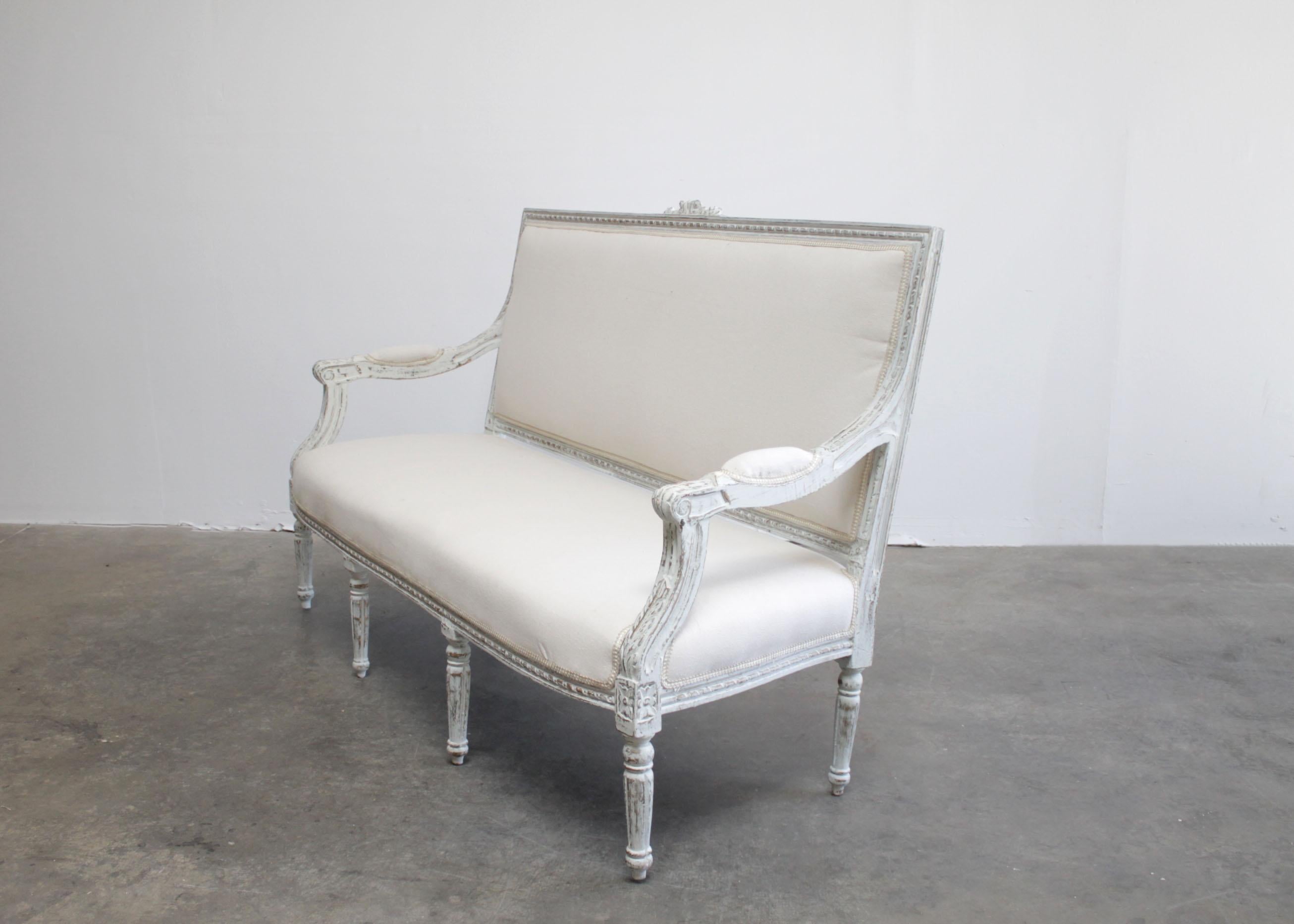This beautiful Louis style settee is painted in a soft white with subtle oyster gray tones.
A little bit of gilt and wood color is peeking through the antique distressed finish.
Solid and sturdy ready for everyday use. Upholstered in a solid