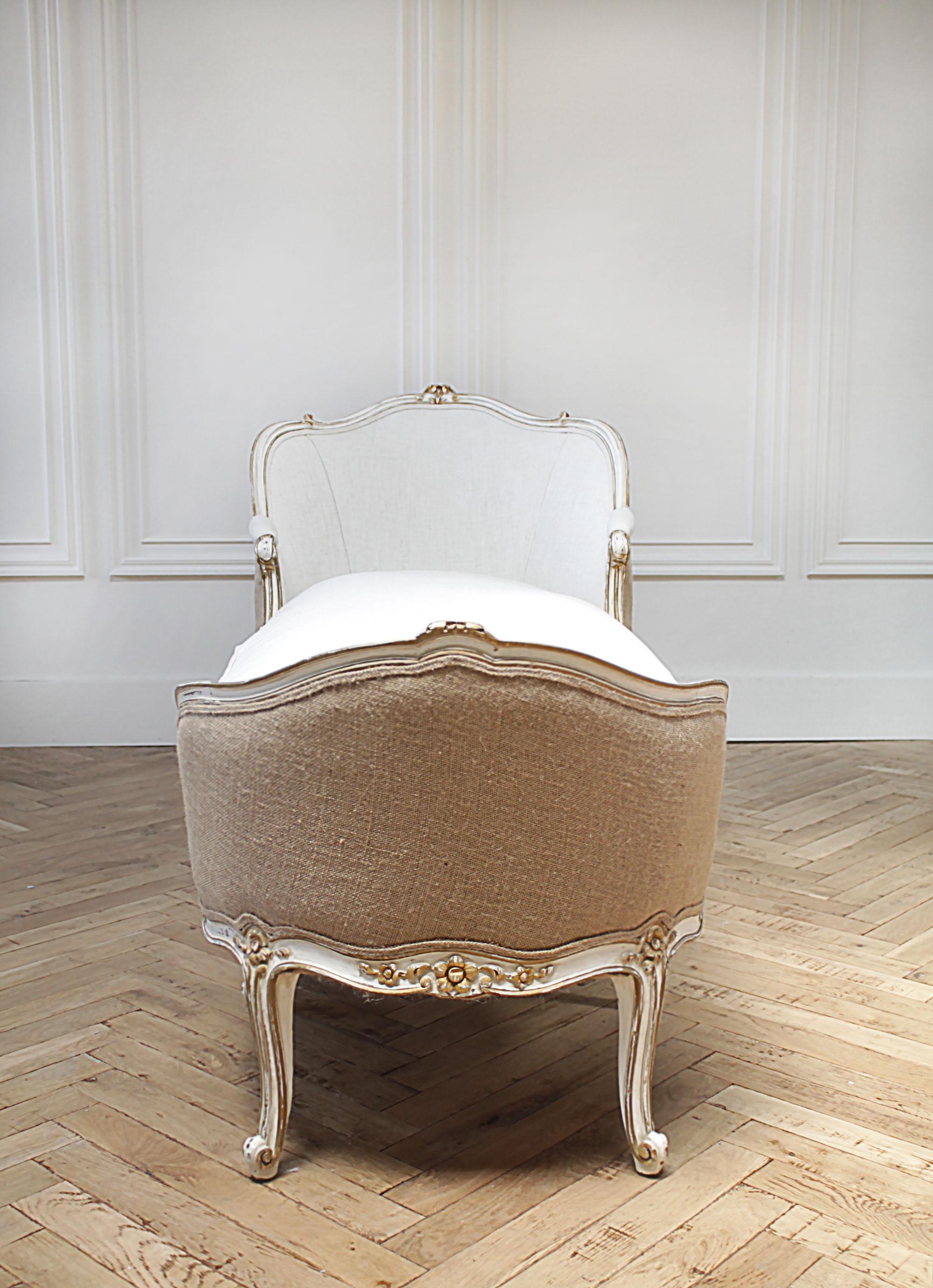Vintage Louis XV style painted and upholstered linen chaise lounge
Painted in an antique white finish with gilt carved edges, subtle distressed patina to the edges. The paint is original to the piece, and has a wonderful aged look.
We