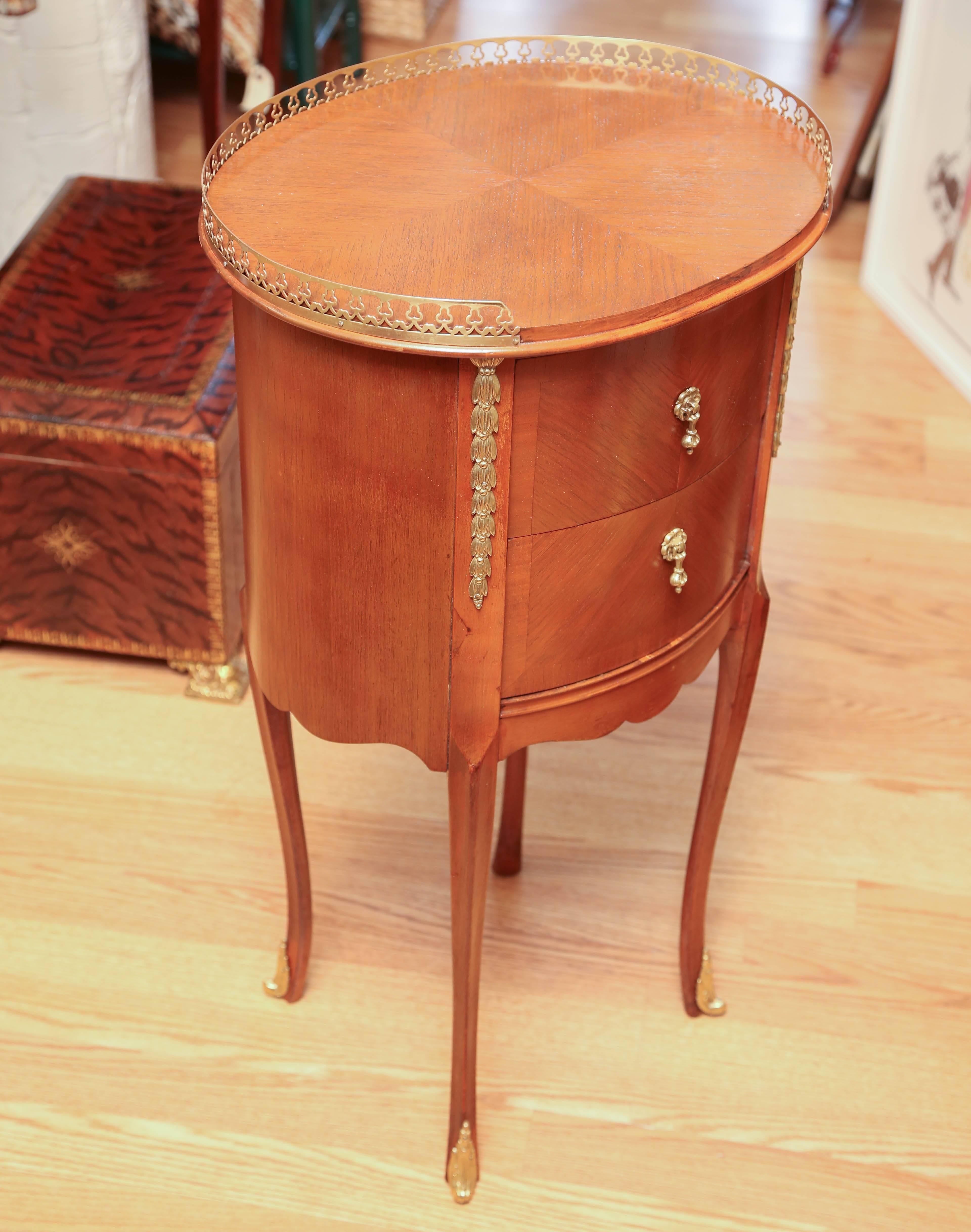 Two drawer oval end table with gallery top by John Stuart.