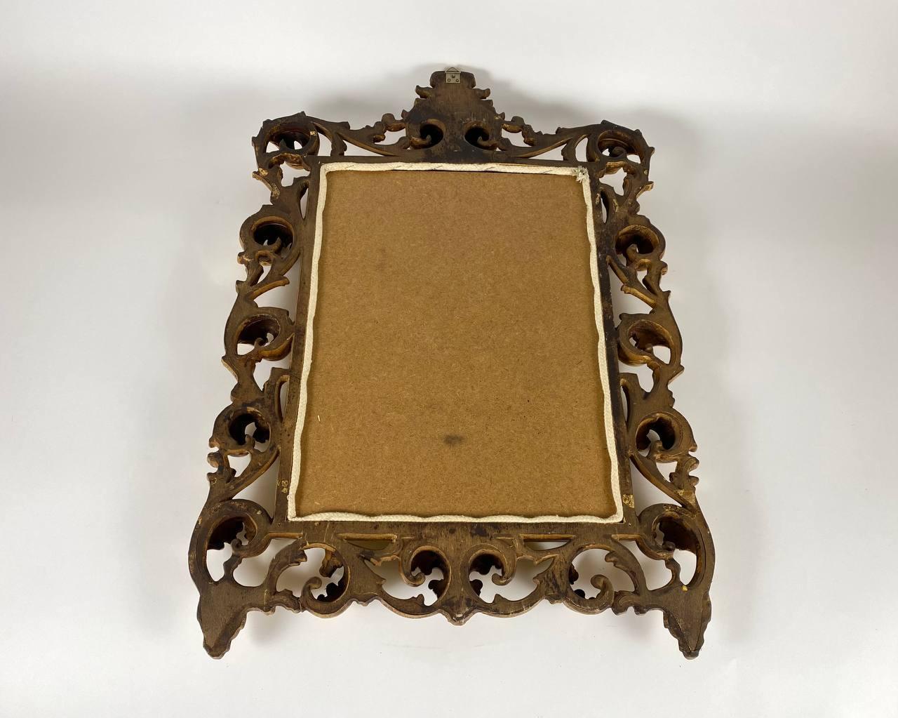 Vintage Miroir en bois sculpté et doré, milieu du 20ème siècle.

Le miroir de forme rectangulaire est orné d'une crête d'acanthe ajourée et enroulée, flanquée de pilastres et de festons floraux.

La structure du cadre est en bois. Très détaillé et