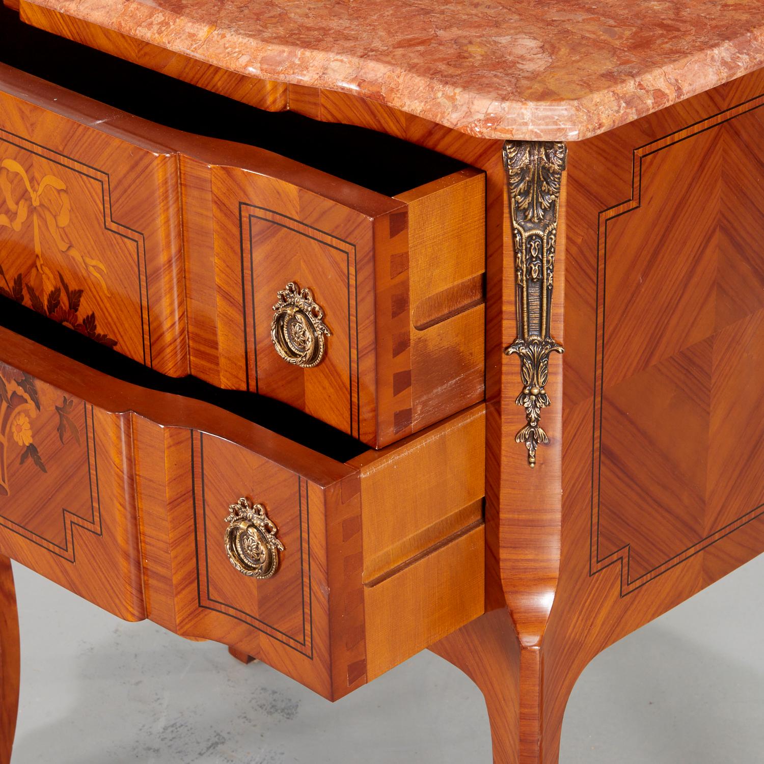 20th c., Louis XV/XVI transitional style inlaid commode with loose shaped rouge marble top, inlaid flower basket design to both drawer fronts on slender cabriole legs with scrolled caps. The sides and front with cross banding and bookmatched veneer.