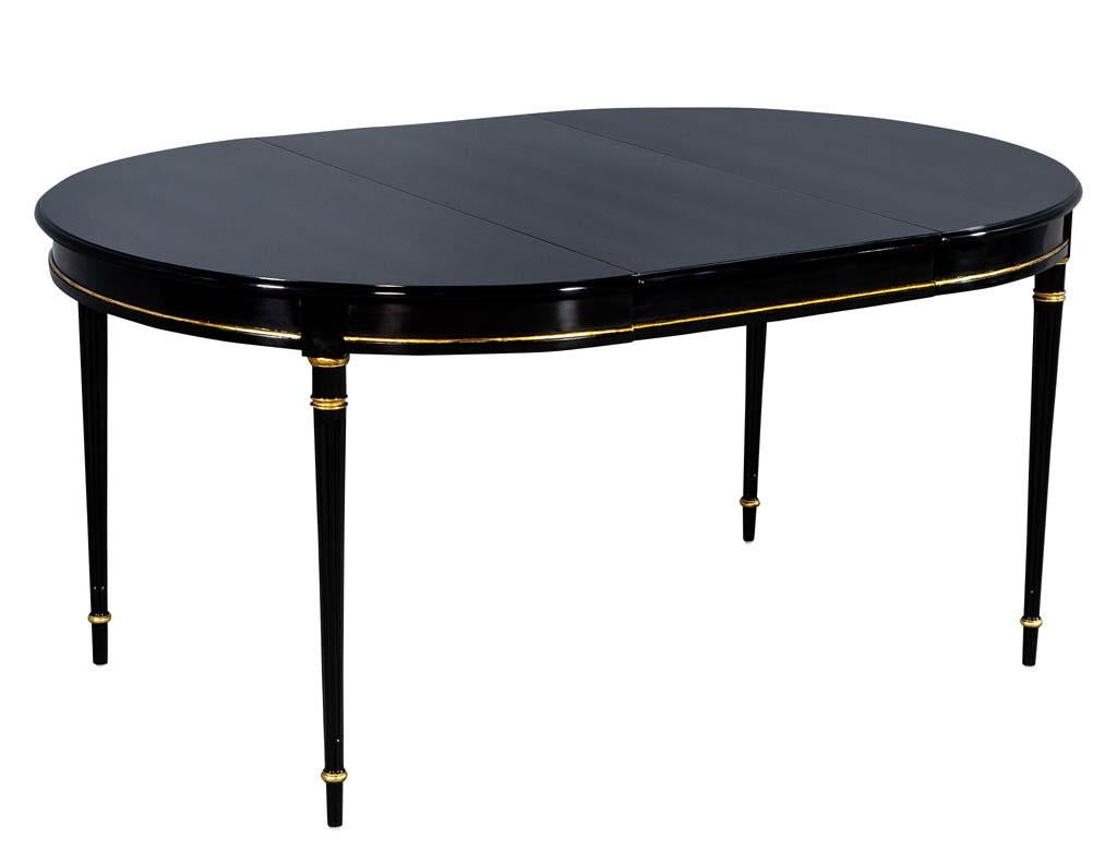 Vintage fully restored Louis XVI styled dining table in a rich hand polished black lacquer with hand painted gold leaf accents. This table has an eclectic classic style that can high light a modern or traditional setting.