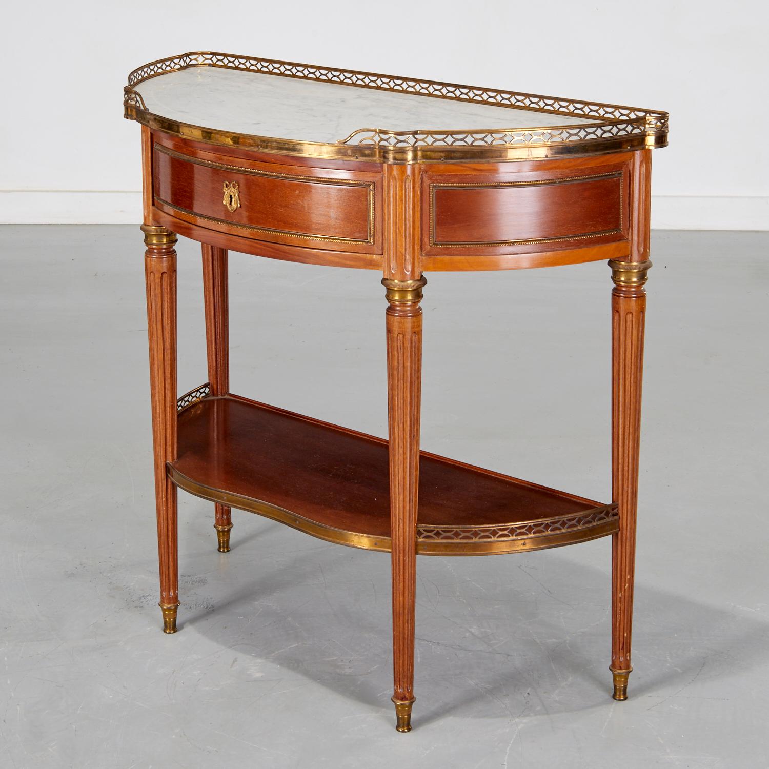 Mid 20th c., a beautiful Louis XVI style bronze mounted demilune console commissioned by celebrity decorator Michael Graves. The console has a marble top with a pierced brass gallery, a single drawer and lower bronze edged shelf on tapering fluted