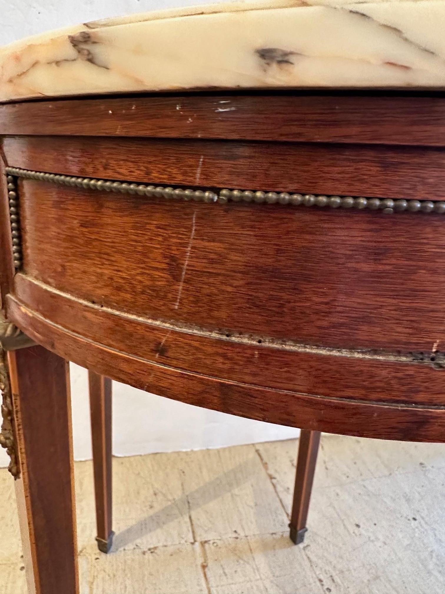 Great looking versatile oval shaped end table having handsome walnut base with decorative brass beading and mounts, topped by a chunky piece of black and white marble.