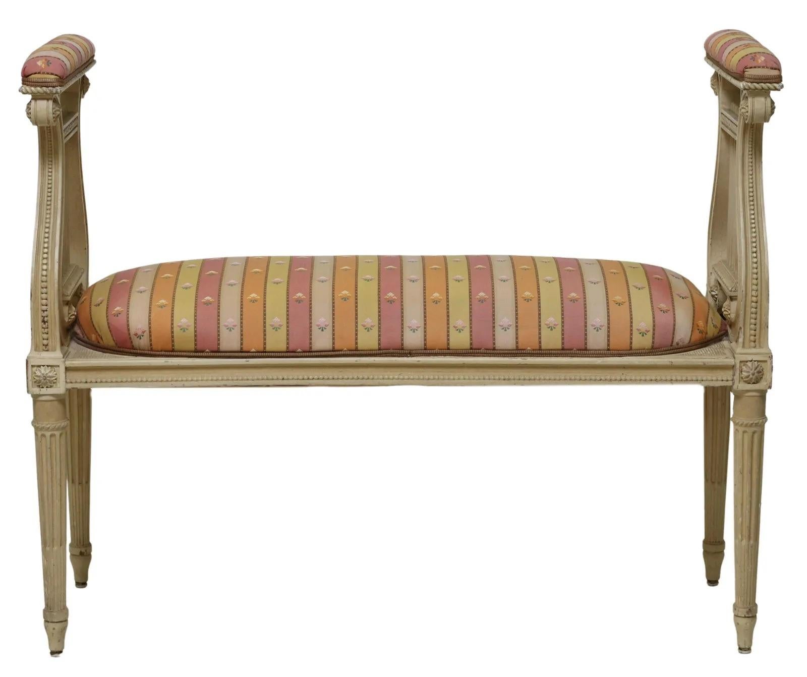 Louis XVI style music or end of bed bench, 20th c., painted in a cream color with two high lyre ends flanking the padded upholstered seat, all rising on tapered ribbed legs.

Dimensions: approx. 32.5