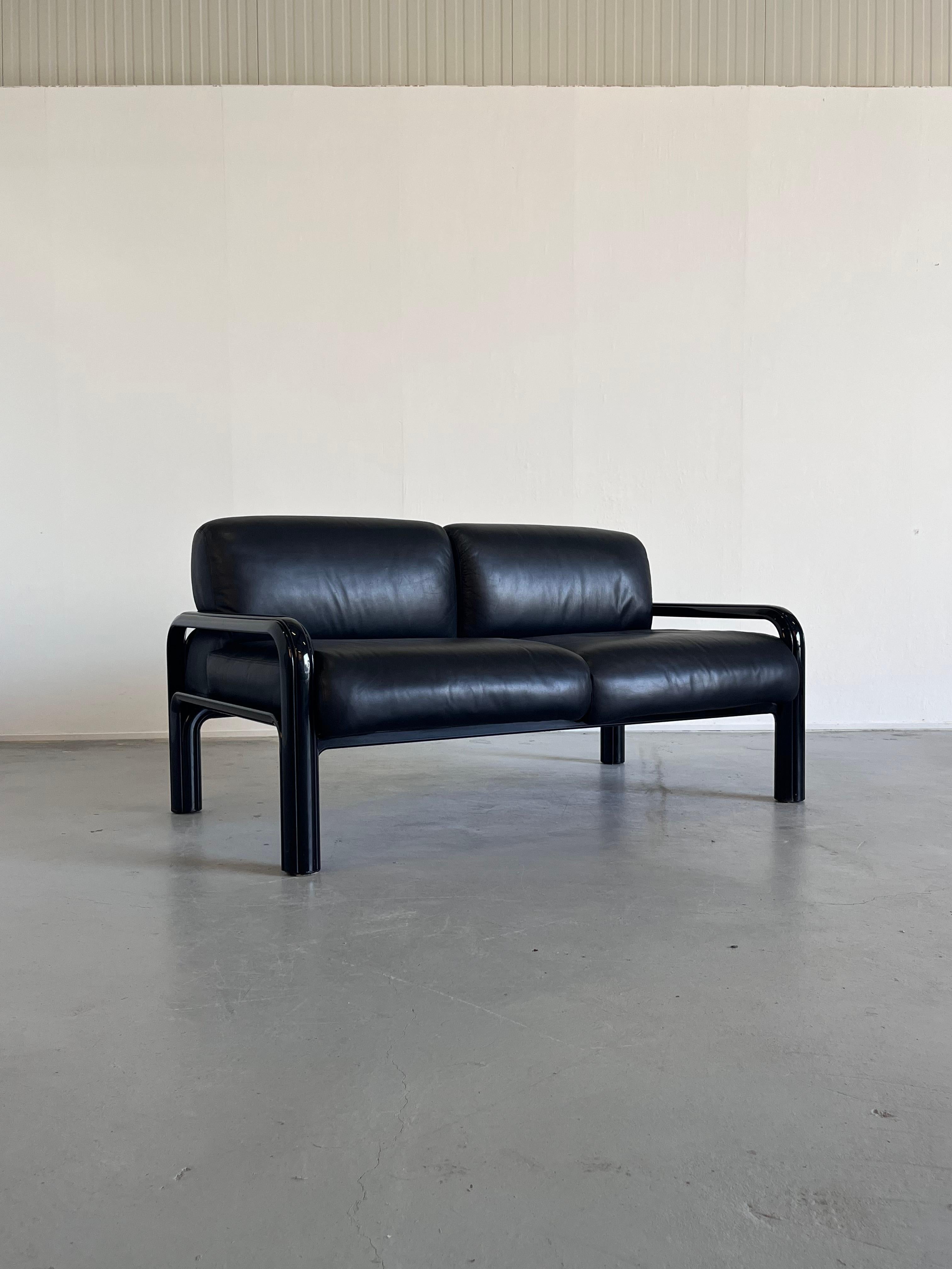 A vintage original loveseat club sofa designed by the Italian designer Gae Aulenti in 1976 as part of the lounge seating line for the Aulenti Collection of Knoll International. The lacquered frames are made from extruded steel and the loose cushions