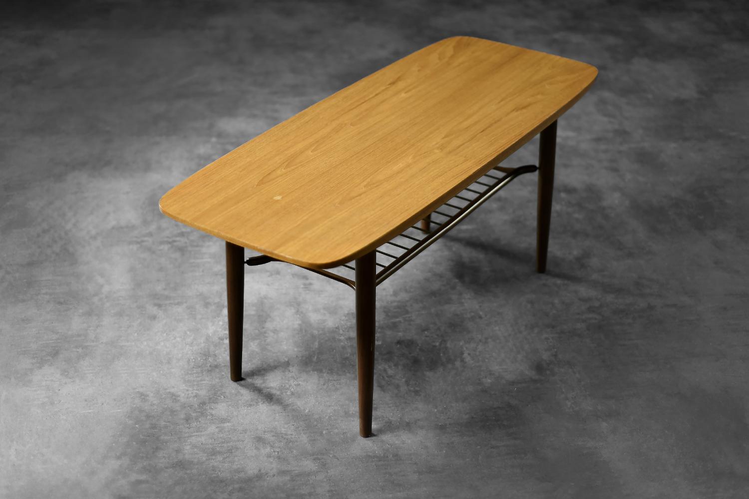 La table basse Hyggebord 55 a été produite par le fabricant danois Gorm Møbler en 1956. Le plateau arrondi est fabriqué en teck de haute qualité et les pieds élancés sont en afromosia. Cette table possède une étagère ouverte sous le plateau.