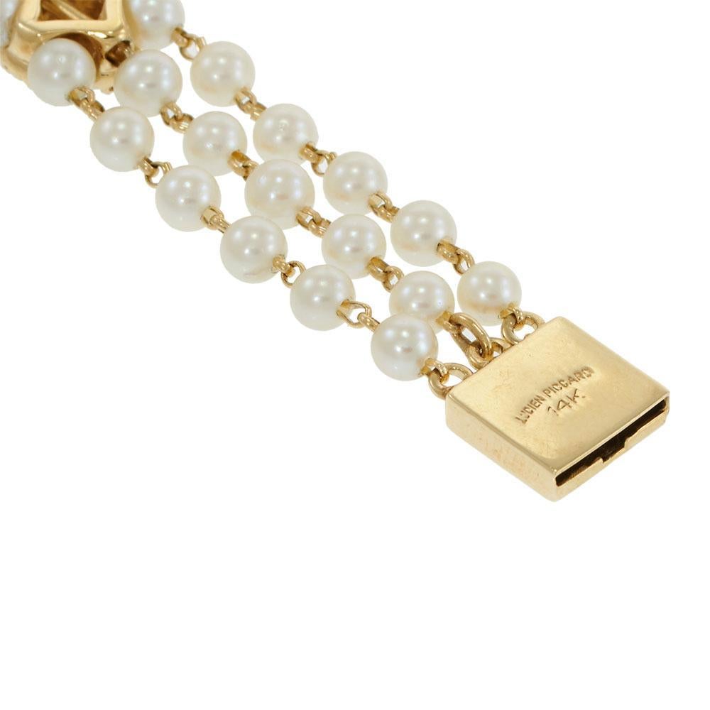 Dieses Armband im Vintage-Stil von Lucien Piccard verbindet sanften Glanz mit liebevollen Details. Drei Reihen leuchtender 4-4,5 mm Akoya-Perlen werden durch fünf mit Granat umrahmte Herzstücke aus 14 Kt Gelbgold verbunden. Dieses Armband mit