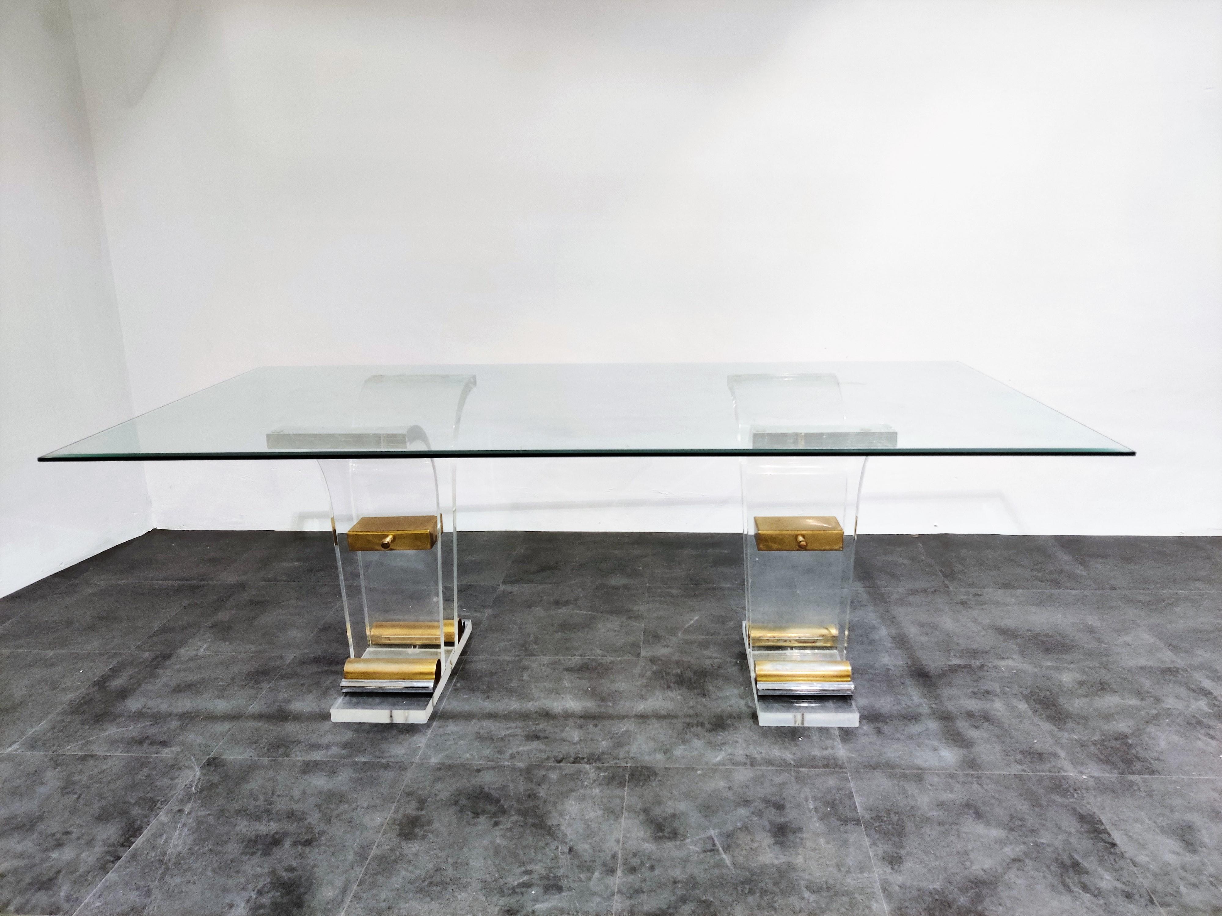 Beautiful Hollywood Regency dining table.

Beveled rectangular glass top.

Brass and Lucite arched bases.

Timeless piece.

The table is in good condition, minor damages to the glass.

1970s - Italy

Measures: Height 72cm/28.34