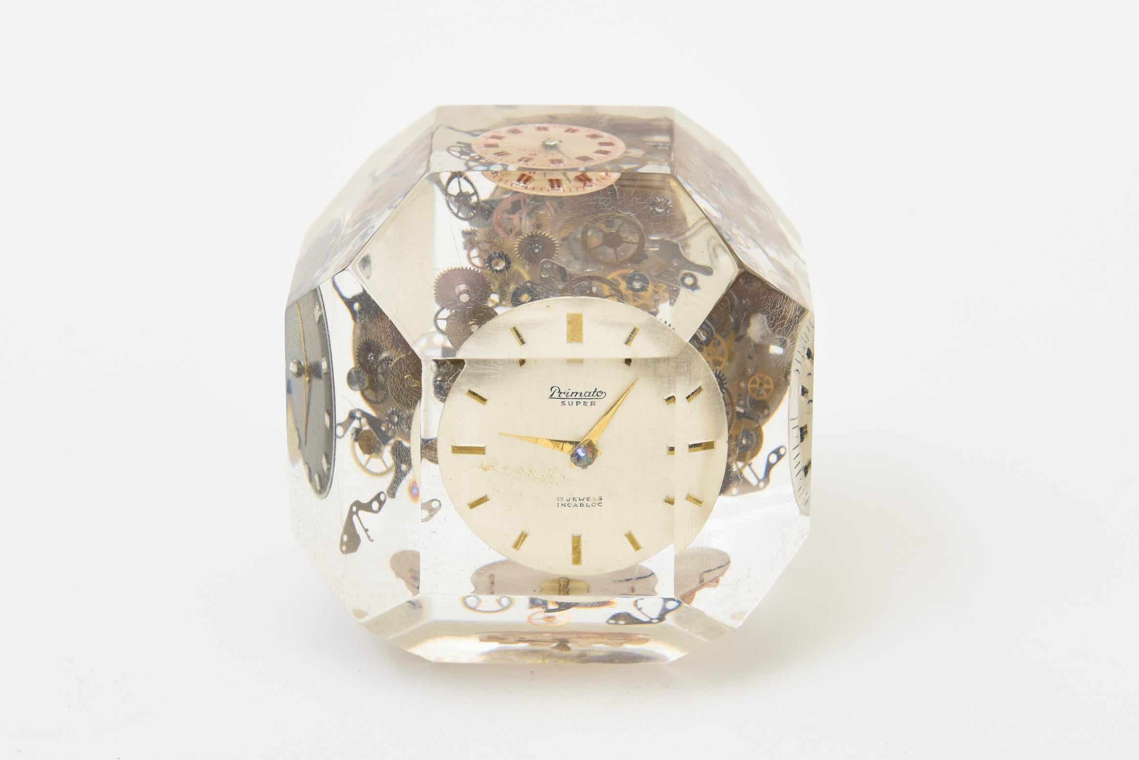 Questo cubo sfaccettato di lucite vintage degli anni '70 è una scultura incastonata piena di parti di orologi. Da ogni angolazione è diverso e molte parti metalliche galleggiano. è di 3,5