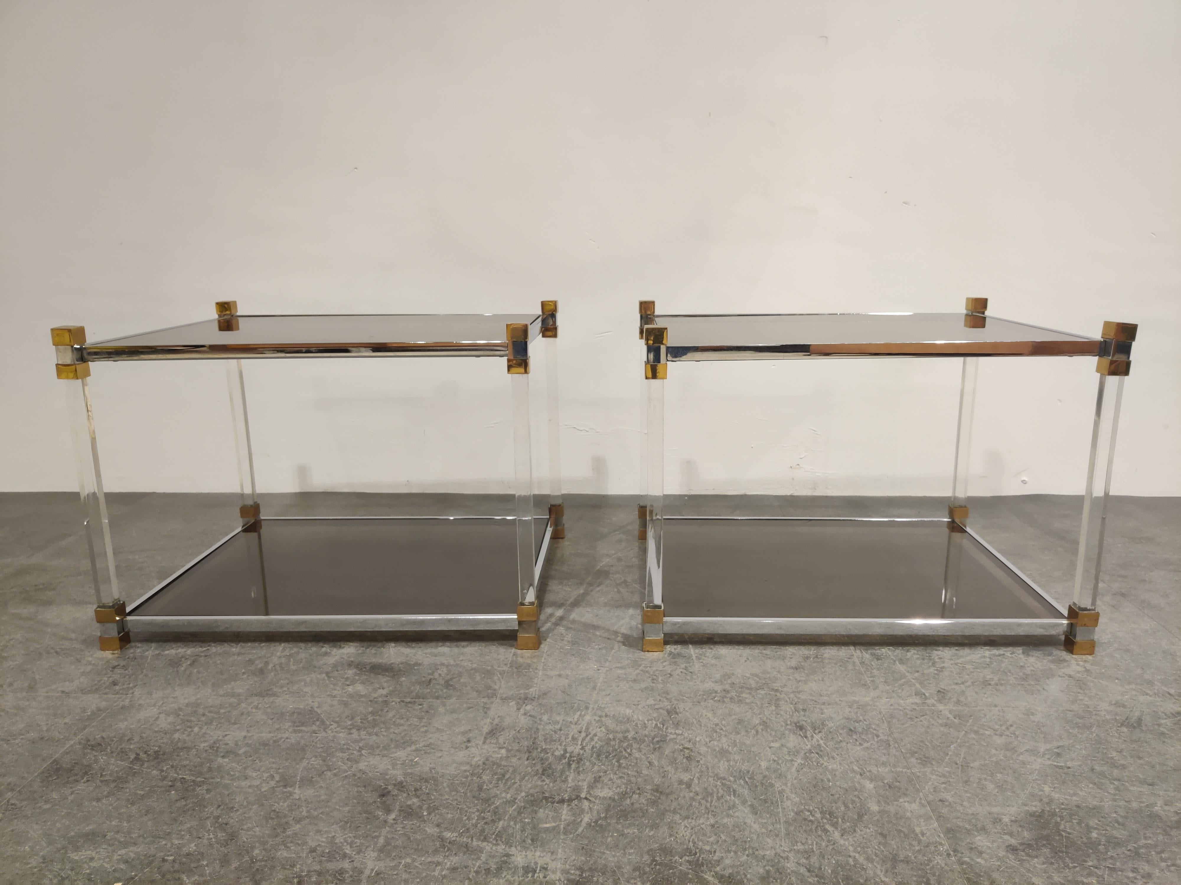 Gorgeous pair of Lucite, brass and chrome coffee or side tables with a smoked glass top.

Good overall condition.

These tables where manufactured by high end furniture company 'Belgochrom' which no longer exists.

Fun fact, these tables where