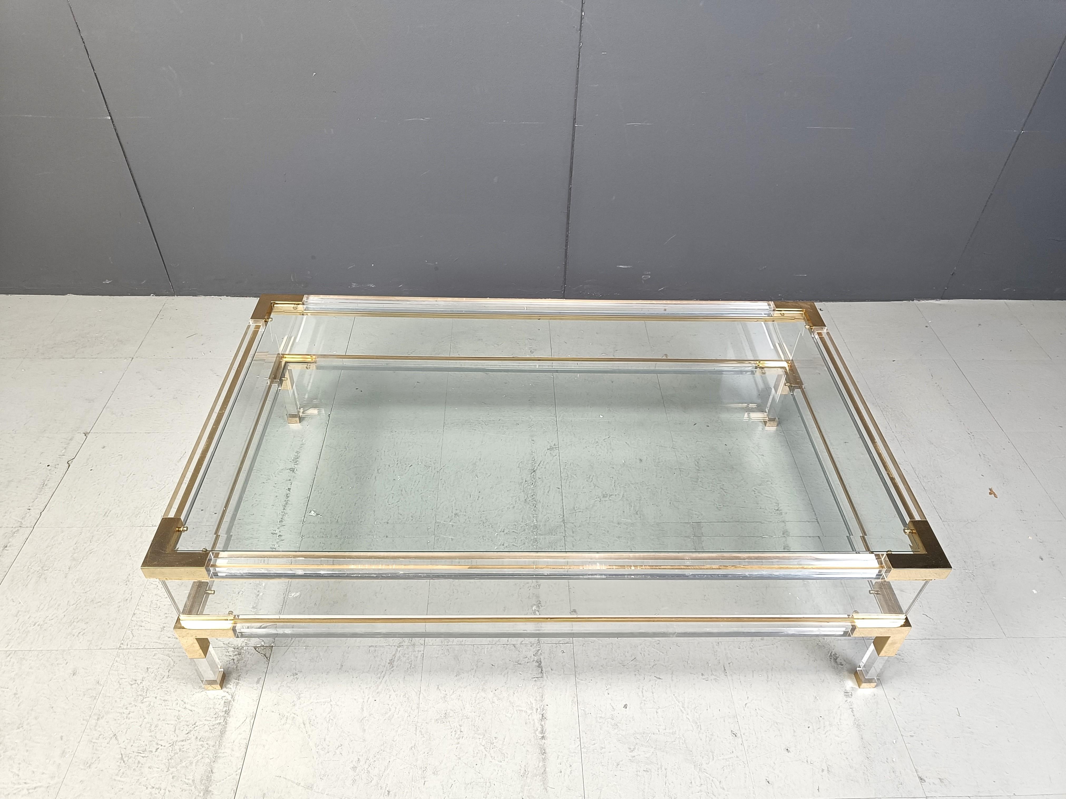 
Vintage display coffee table with a sliding glass top. - In the manner of Charles Hollis Jones, produced by Belgochrom

This luxurious coffee table is made from brass, glass and plexi

It is ideal to display curio and store magazines, scale models,