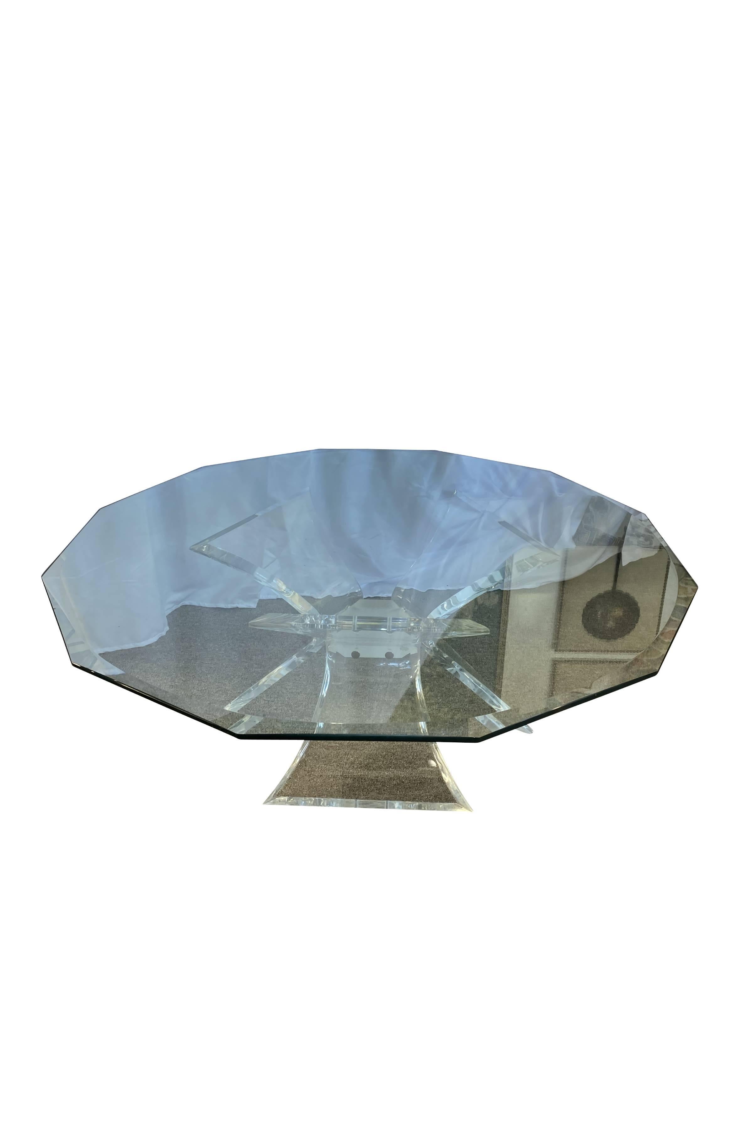 This unique coffee table features an modern Lucite base where three curved hourglass shaped legs support the octagonal, beveled glass top. The glass top allows an unobstructed view of the table’s unique and balanced base construct.