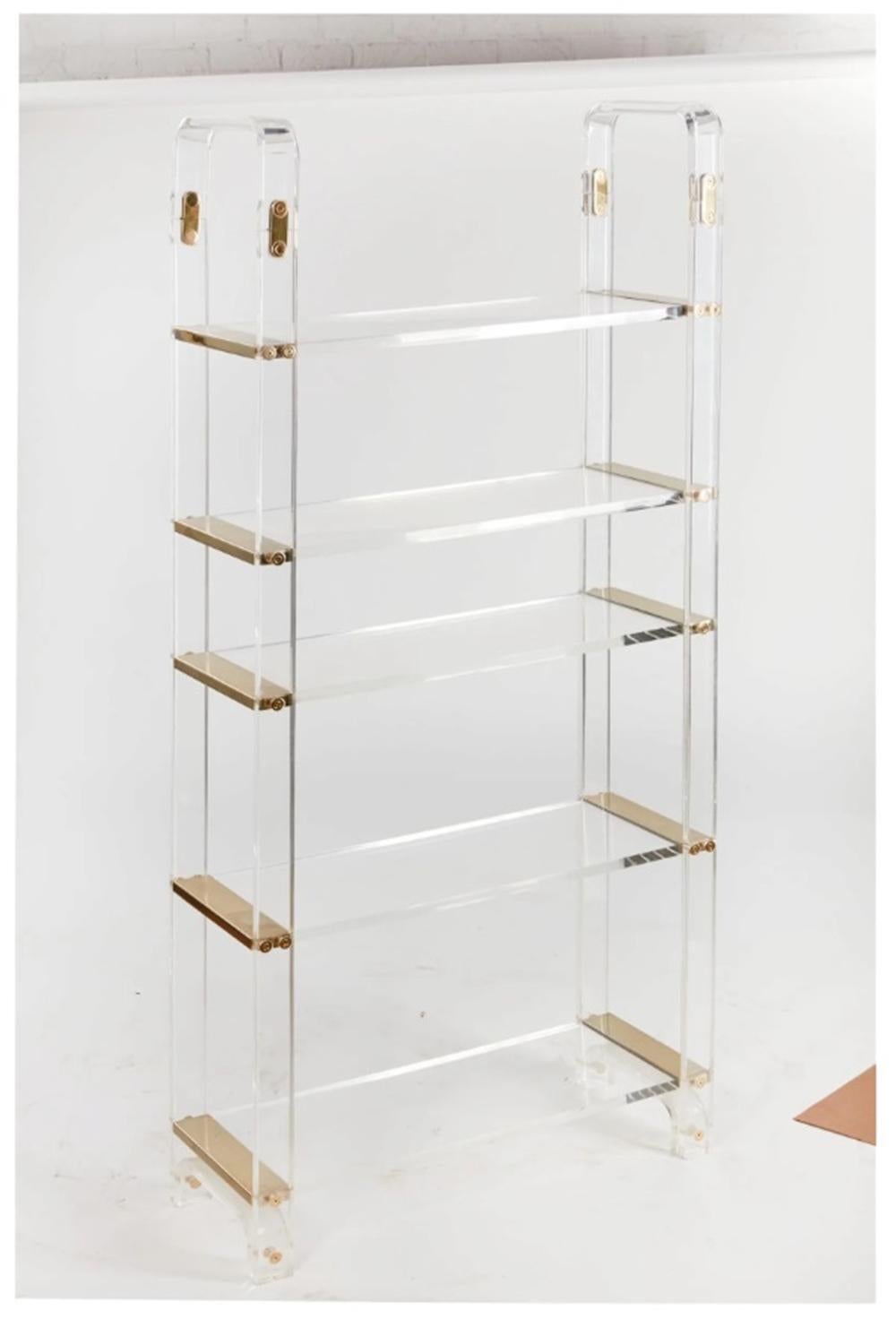 Introducing the Vintage Lucite & Brass Etagere, inspired by the iconic designs of Charles Hollis Jones. This stunning piece of furniture is a true statement piece, perfect for adding a touch of vintage glamour to any space.

Crafted from