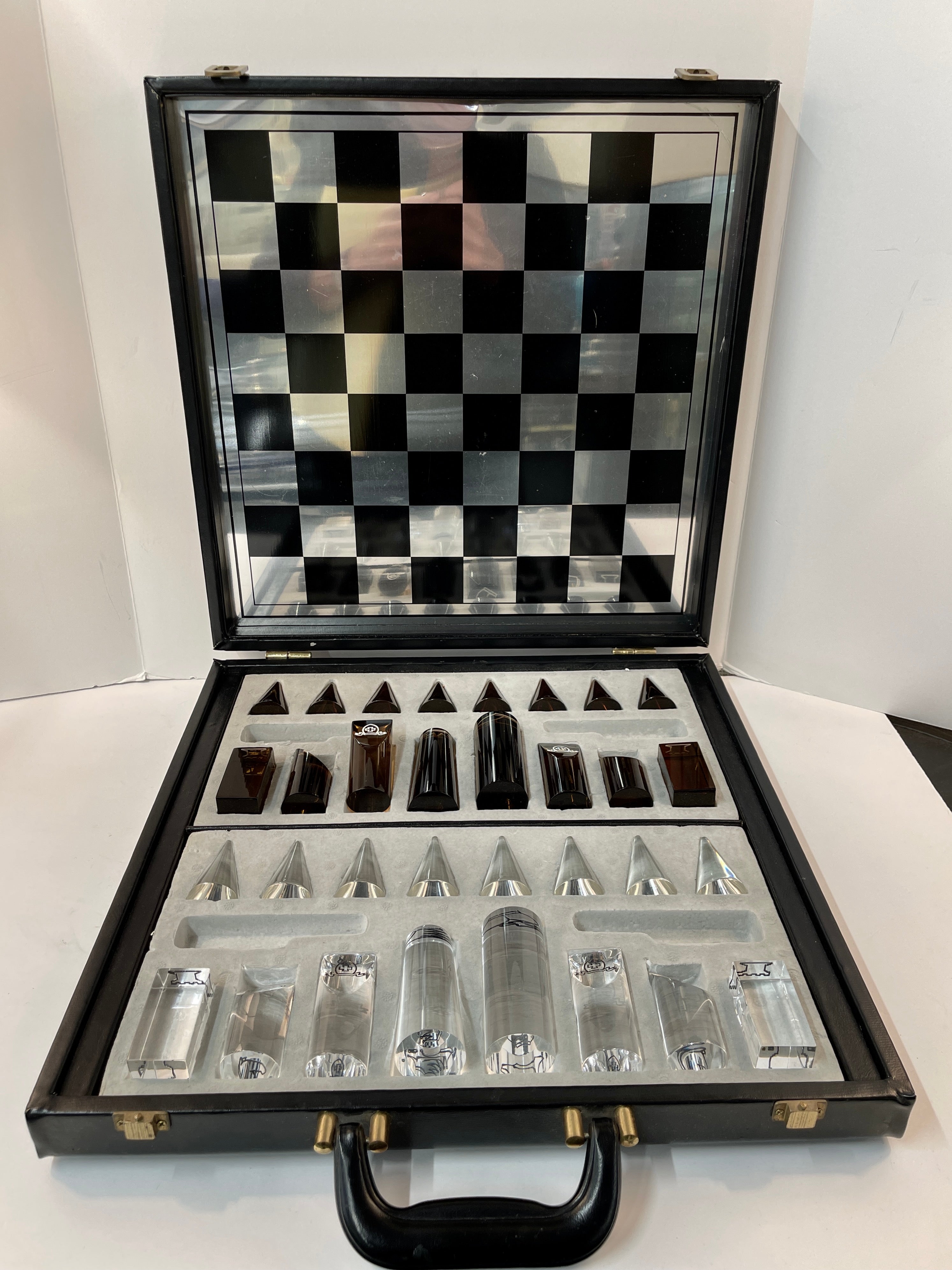 1970’s lucite chess set. The pieces are in a smoky brown and clear acrylic with a fitted case with a board built into the top. The case is vinyl I believe. The case is approximately 16 inches square. Tallest piece. Is 3.5 inches tall. The pawns are
