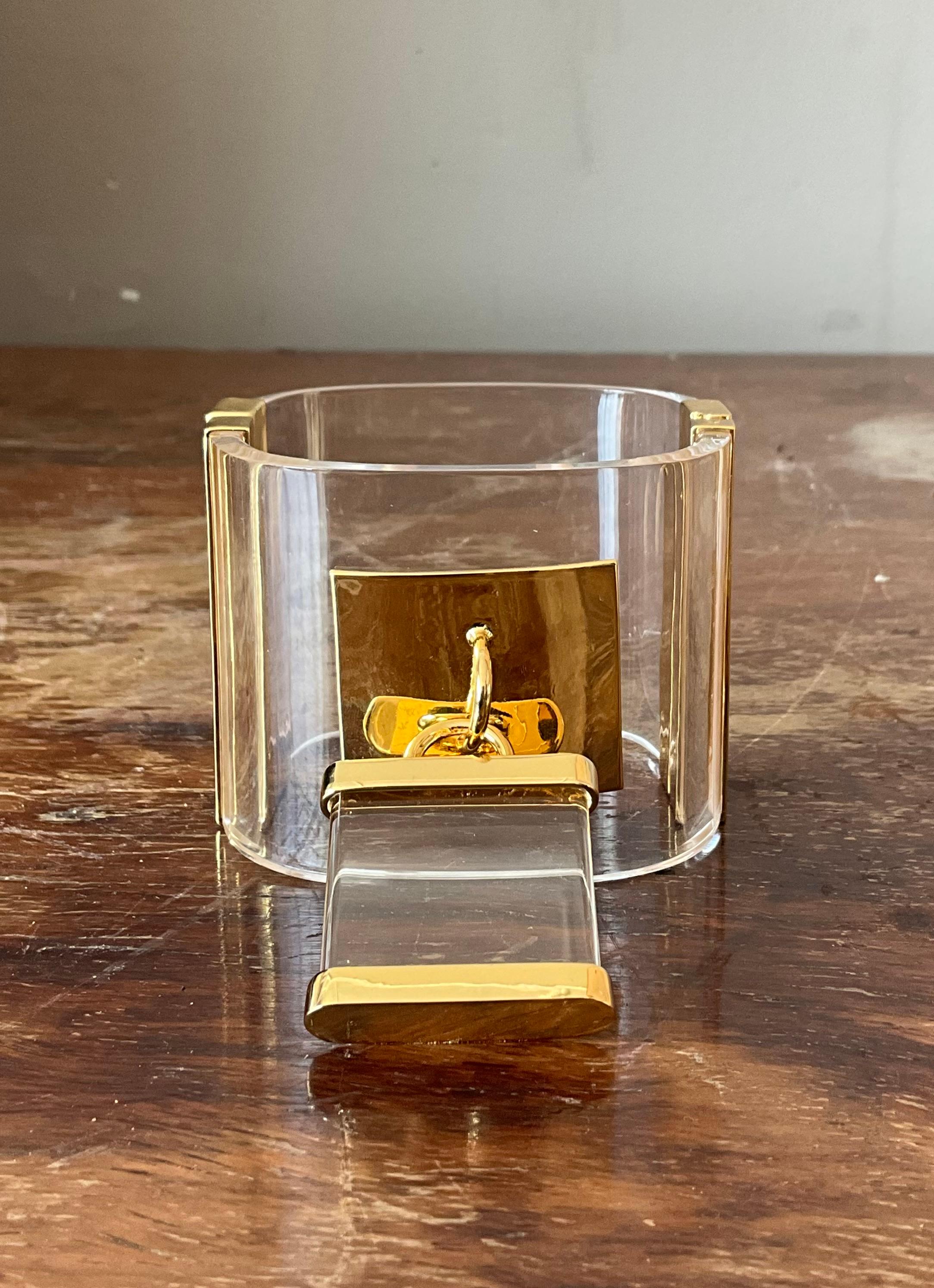 This vintage Lucite lock bracelet is a striking blend of retro charm and modern convenience. Crafted from high-quality Lucite, it features a bold, translucent design that catches the light beautifully. The chunky, geometric links create a statement
