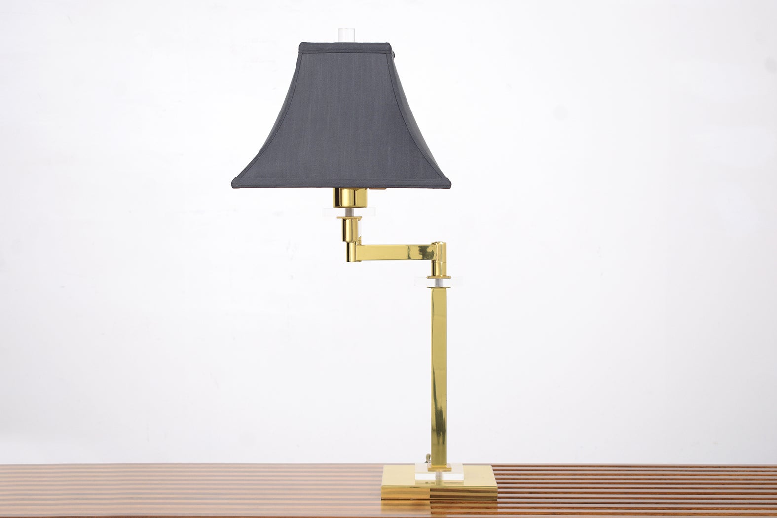 Experience the blend of mid-century charm and modern design with our handcrafted brass and lucite table lamp. This stylish mid-century modern table lamp, meticulously restored by our expert craftsmen, is in great condition and ready to illuminate