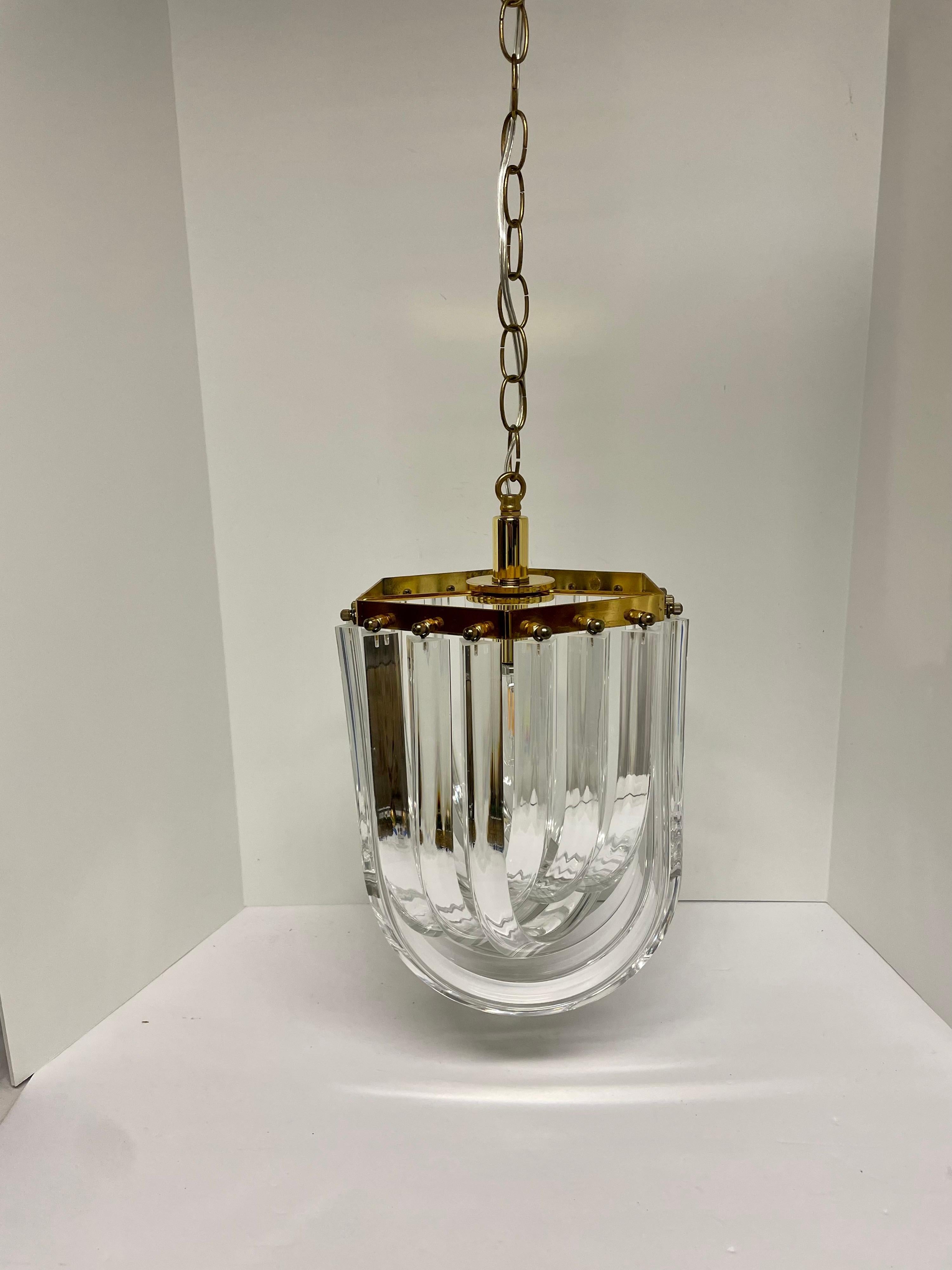 Mid-century style six sided lucite ribbon chandelier. One socket with brass frame and chain. Measure: 10