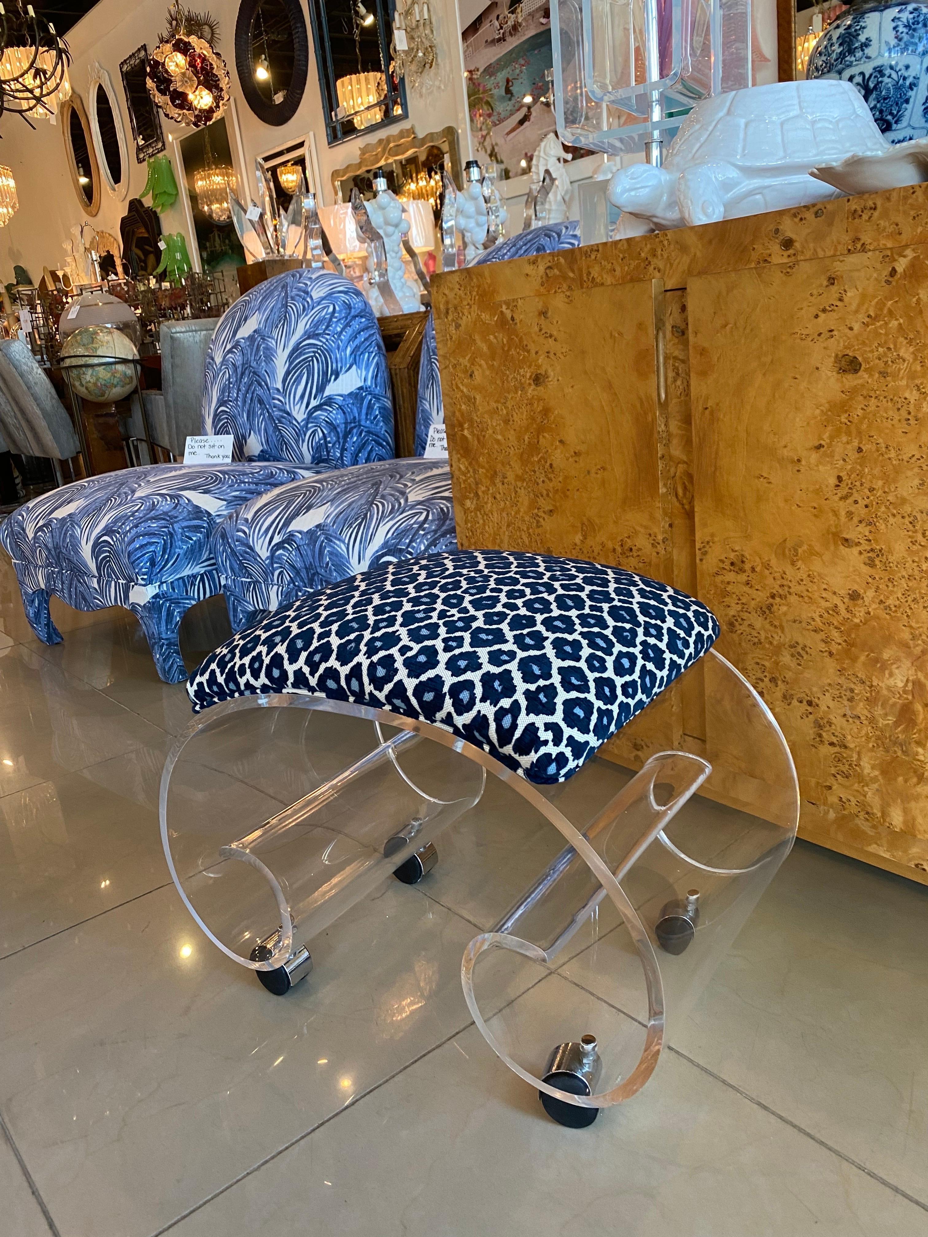 Amazing lucite vanity stool bench with castors. Beautiful ming scroll rare design. Polished and newly upholstered. Dimensions: 17 H x 22.25 W x 13.75 D.