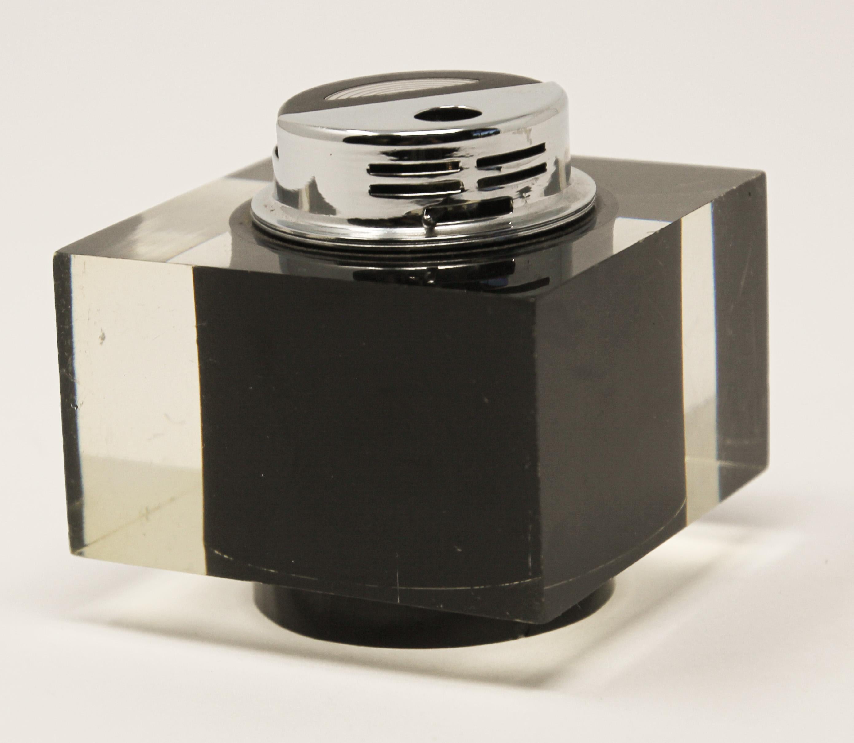Vintage retro 1970s Lucite cube table lighter-paperweight.
Mid-Century Modern retro square lighter in black and clear Lucite with chrome.
A dramatic accent to any modern living room decor, this square lighter will elevate any coffee table or desk