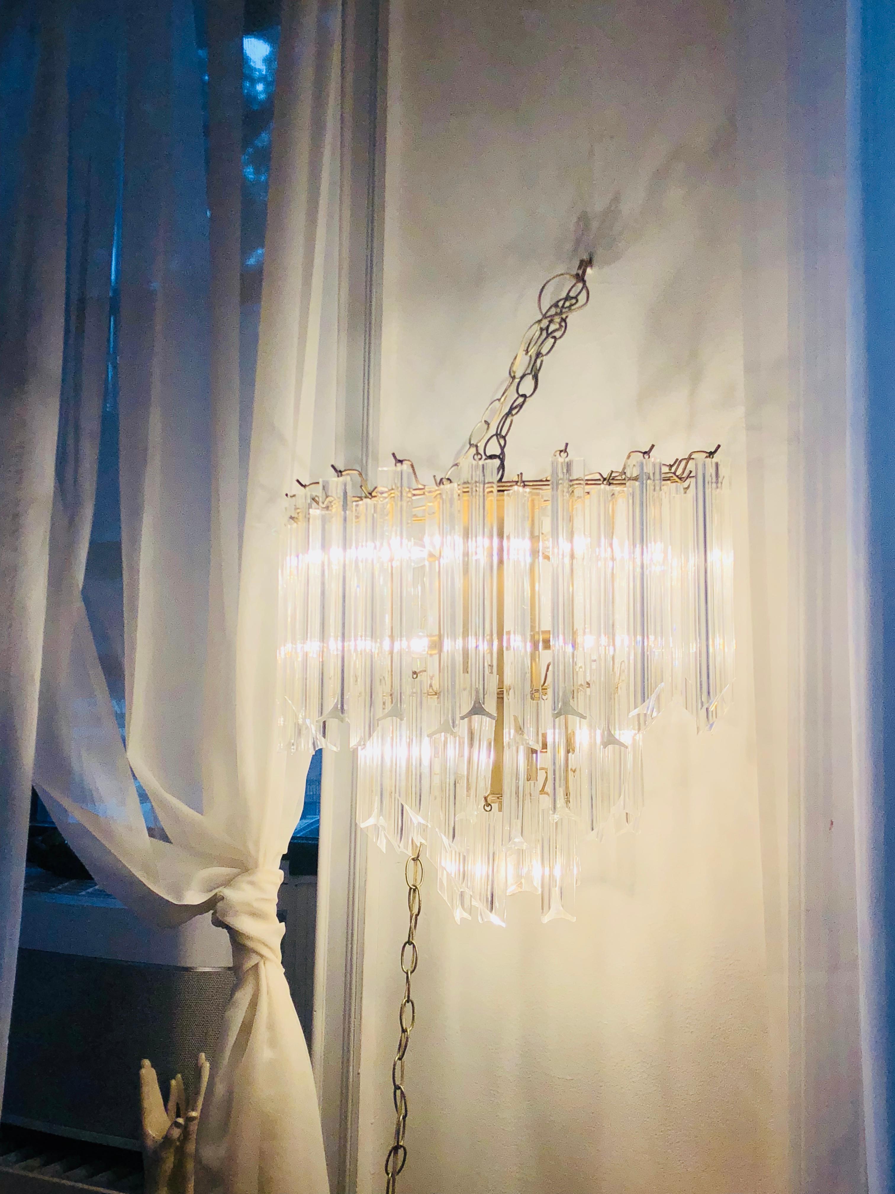 Stellar Lucite midcentury chandelier, three-tiered, in the manner of the iconic Camer glass chandelier (and it's lush adornment with thick Venini triedri (Lucite) crystals.
