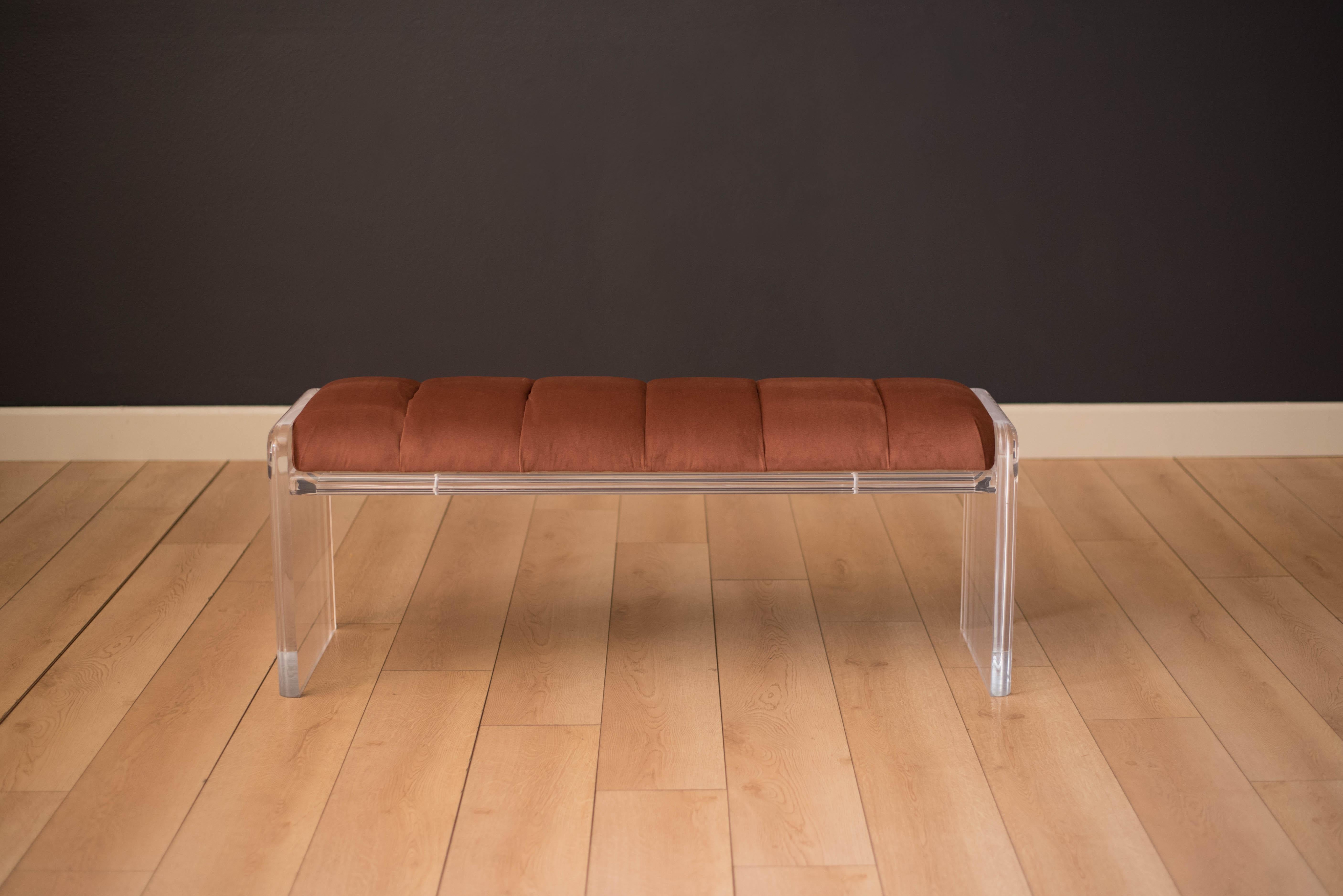Mid-Century Modern Lucite custom accent bench manufactured by Carmichael Designs. This piece has been newly reupholstered with tufted pleats of copper rust velvet. Supported by a clear and transparent heavy acrylic base that adds an illusive sense